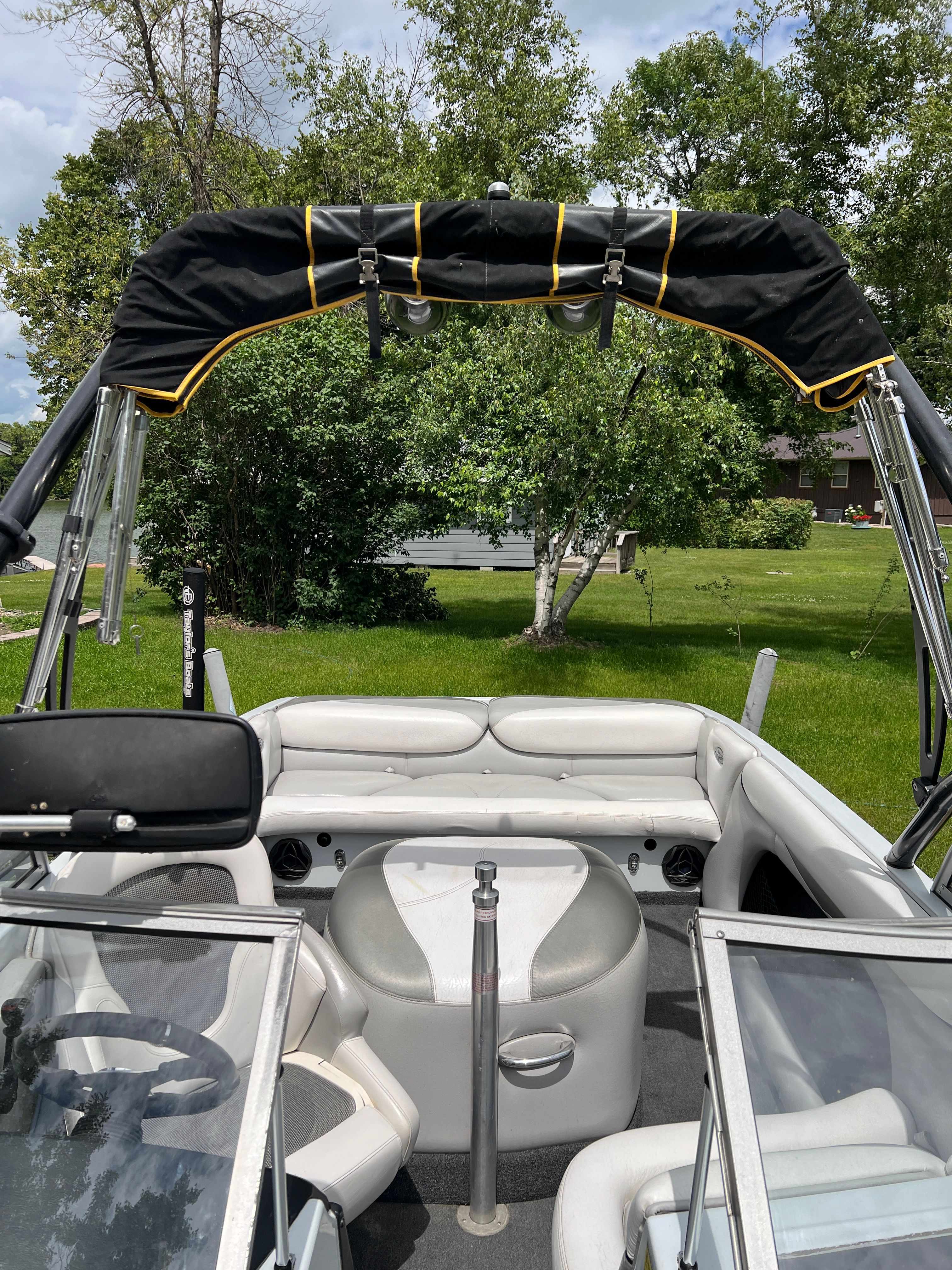 Interior view of a 2006 Tigé 20i boat with white upholstery and a black bimini top.