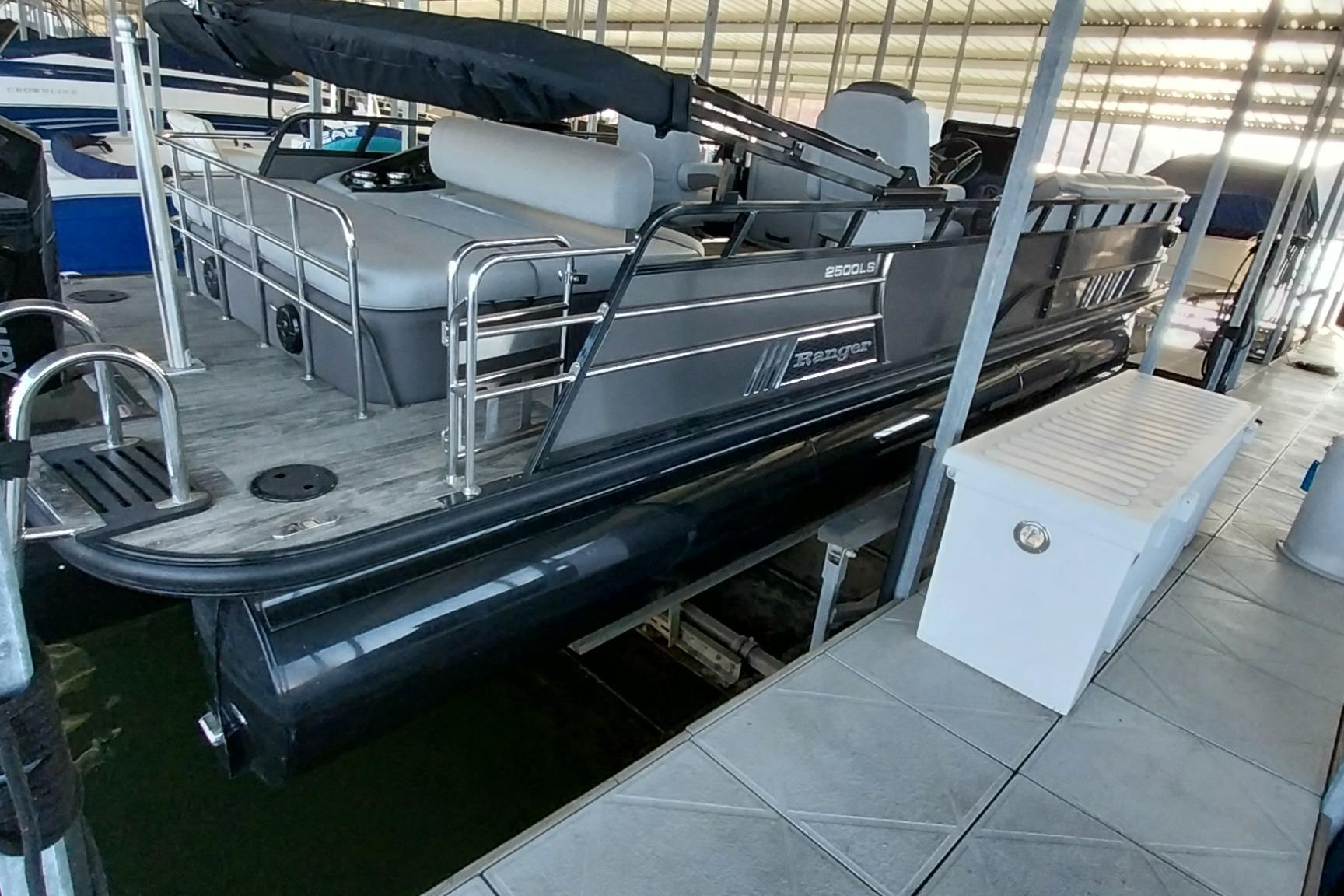2023 Ranger 2500LS pontoon boat docked in a covered marina.