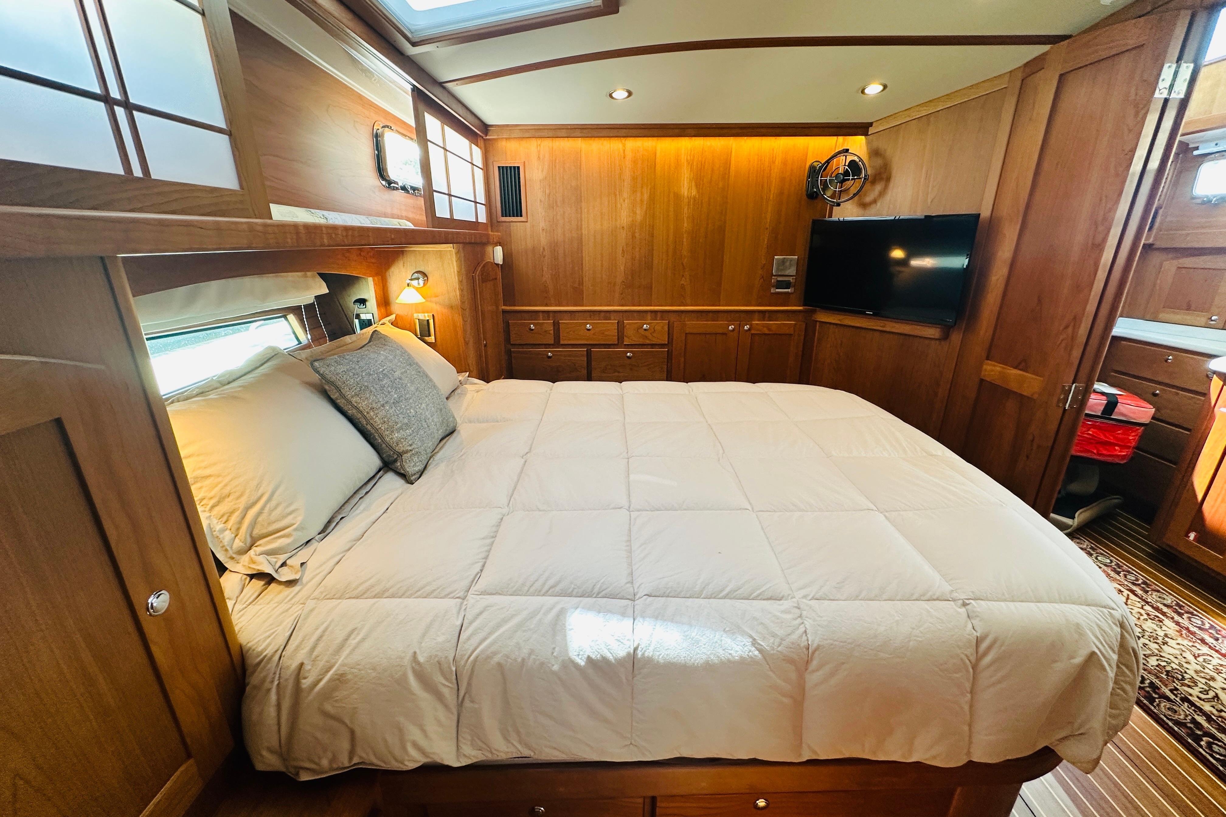 Luxurious bedroom interior of 2025 Sabre 48 Salon Express yacht with wood paneling and cozy bedding.