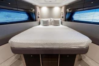 Luxurious bedroom interior of 2019 Azimut Atlantis 51 yacht with modern design and elegant bedding.