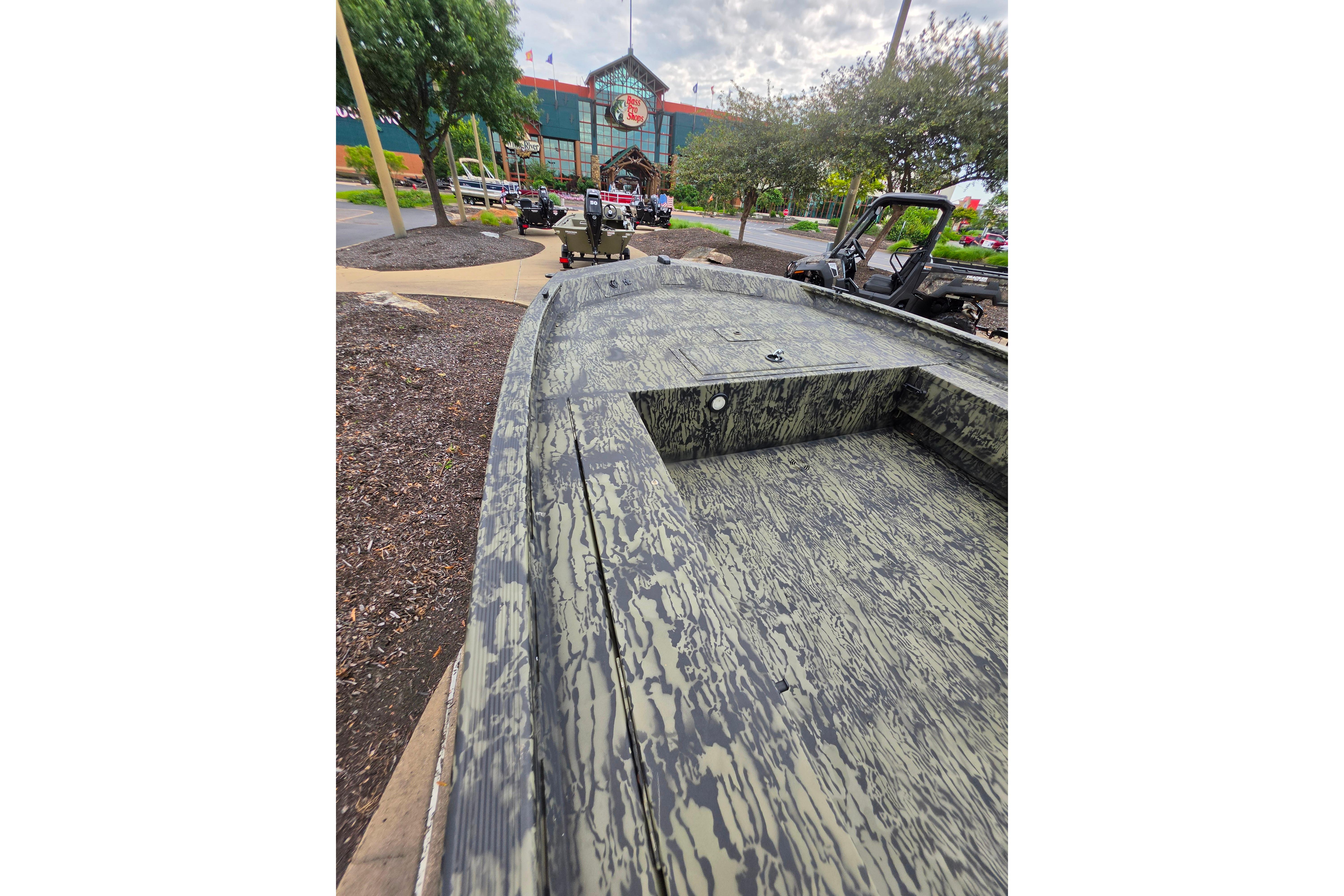 2026 Tracker Grizzly 1654 T Sportsman boat with camouflage design, displayed outdoors.
