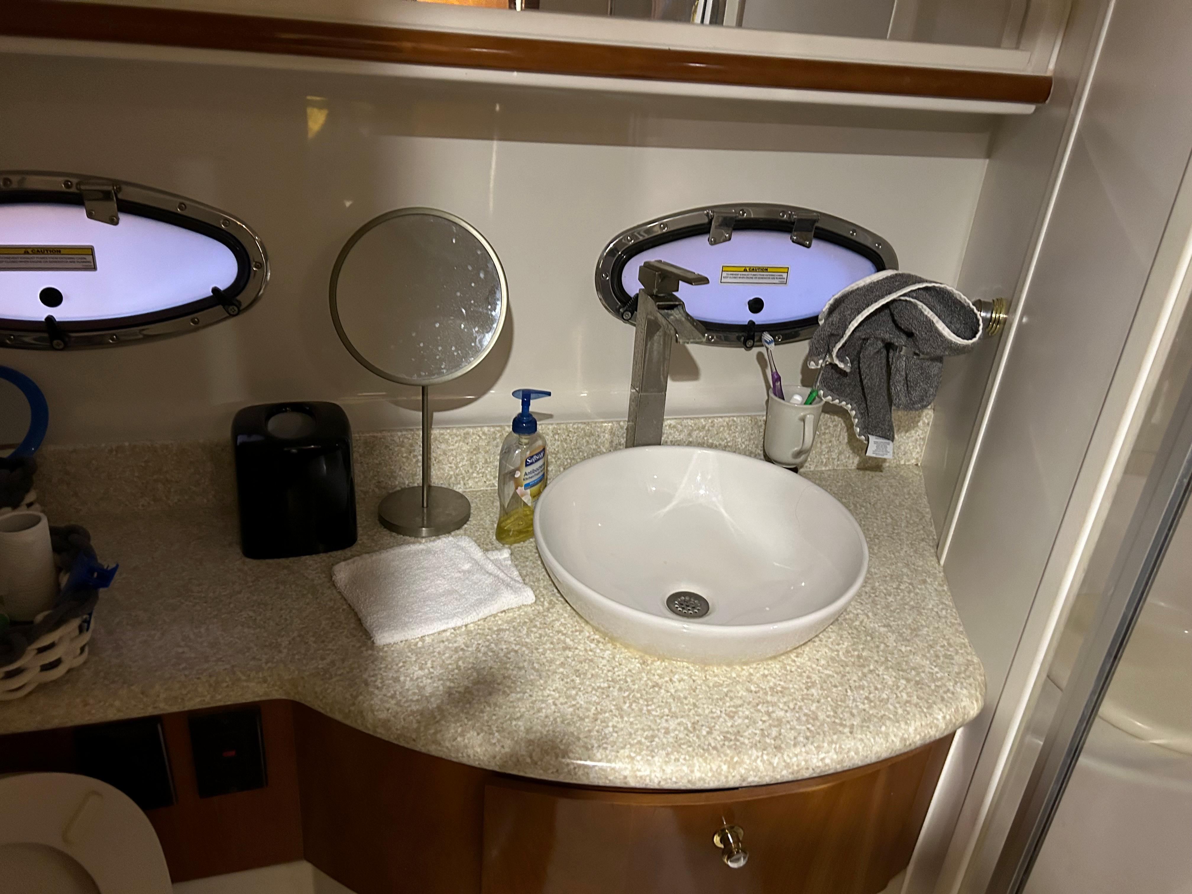 Bathroom sink area in a 2000 Carver 396 yacht with porthole windows.