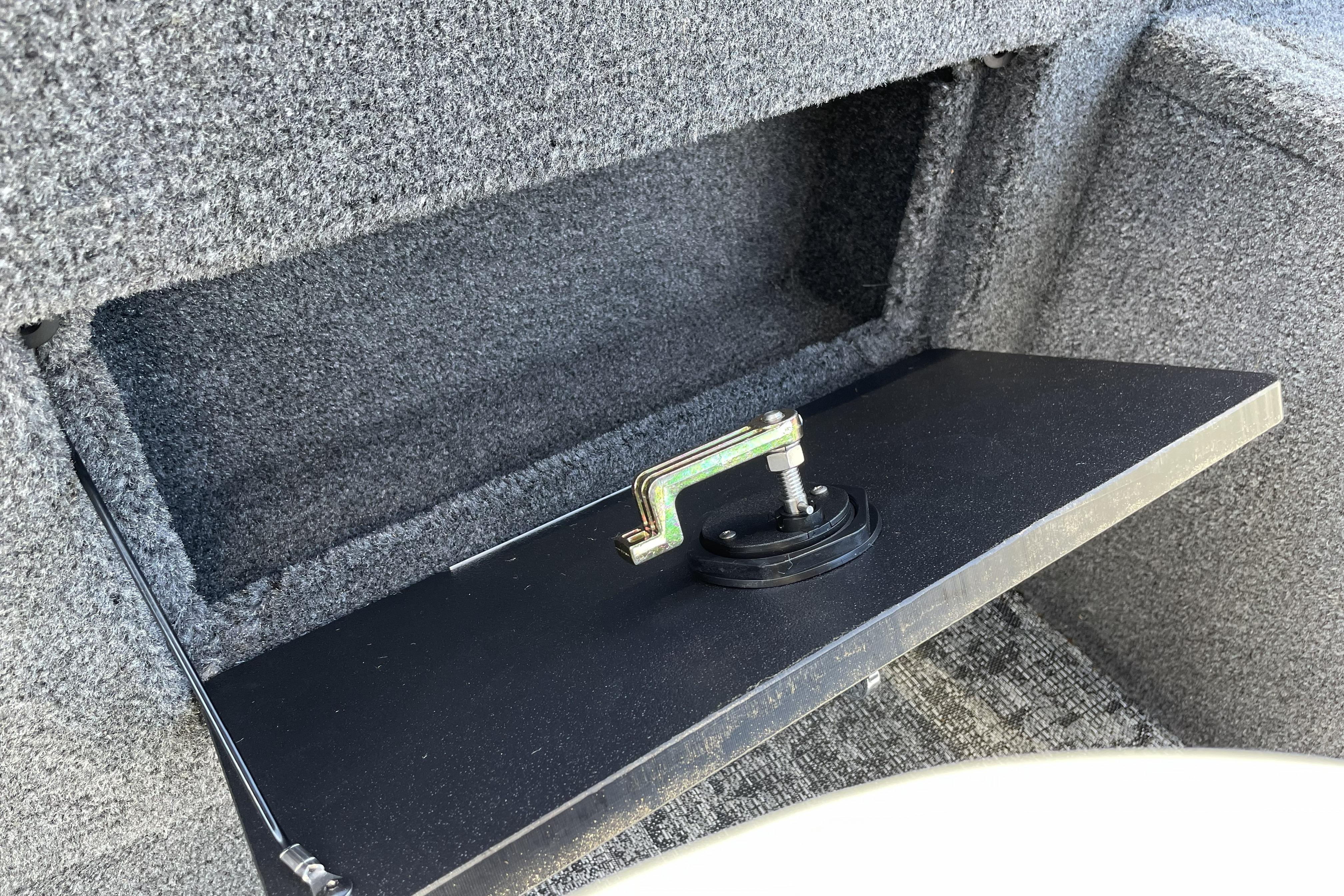 2026 Tracker Targa V-18 WT storage compartment with open hatch and latch mechanism.