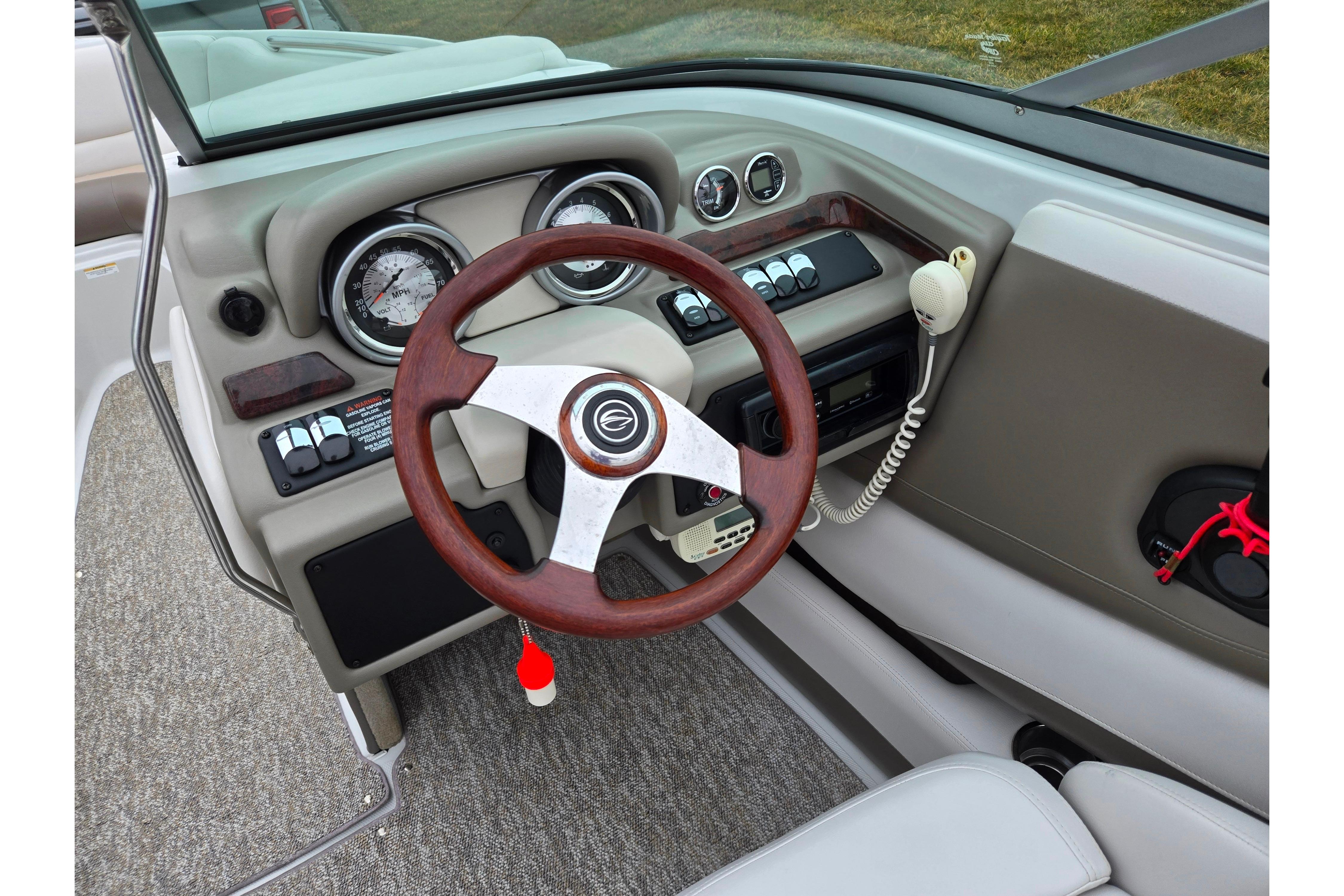 2012 Crownline 235 SS boat dashboard with wood steering wheel and gauges.