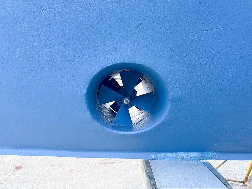 Close-up of a blue bow thruster on a boat hull.