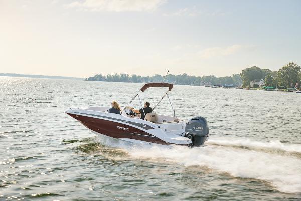 2025 Hurricane SunDeck Sport 205 OB cruising on a serene lake.