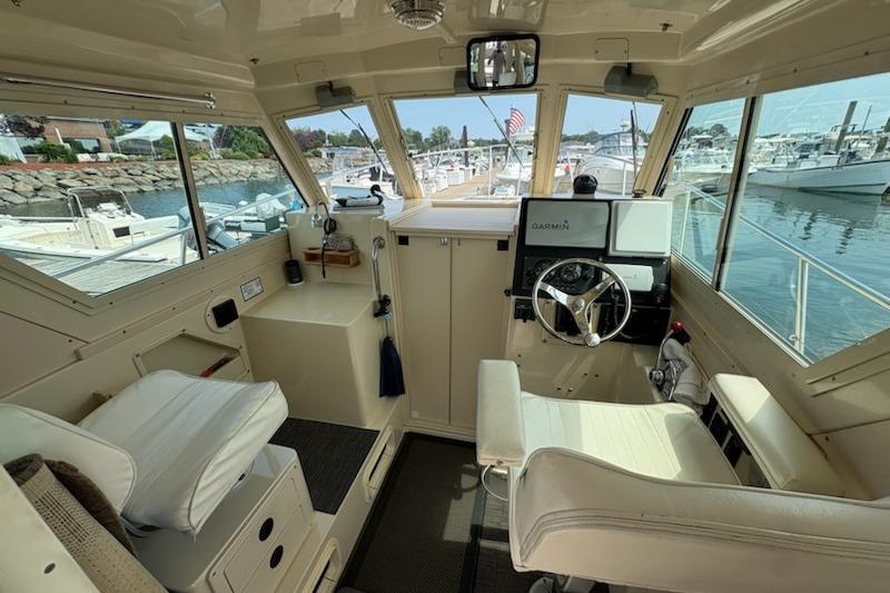Interior view of 2003 Albin 28 Tournament Express boat cockpit with steering wheel and navigation equipment.