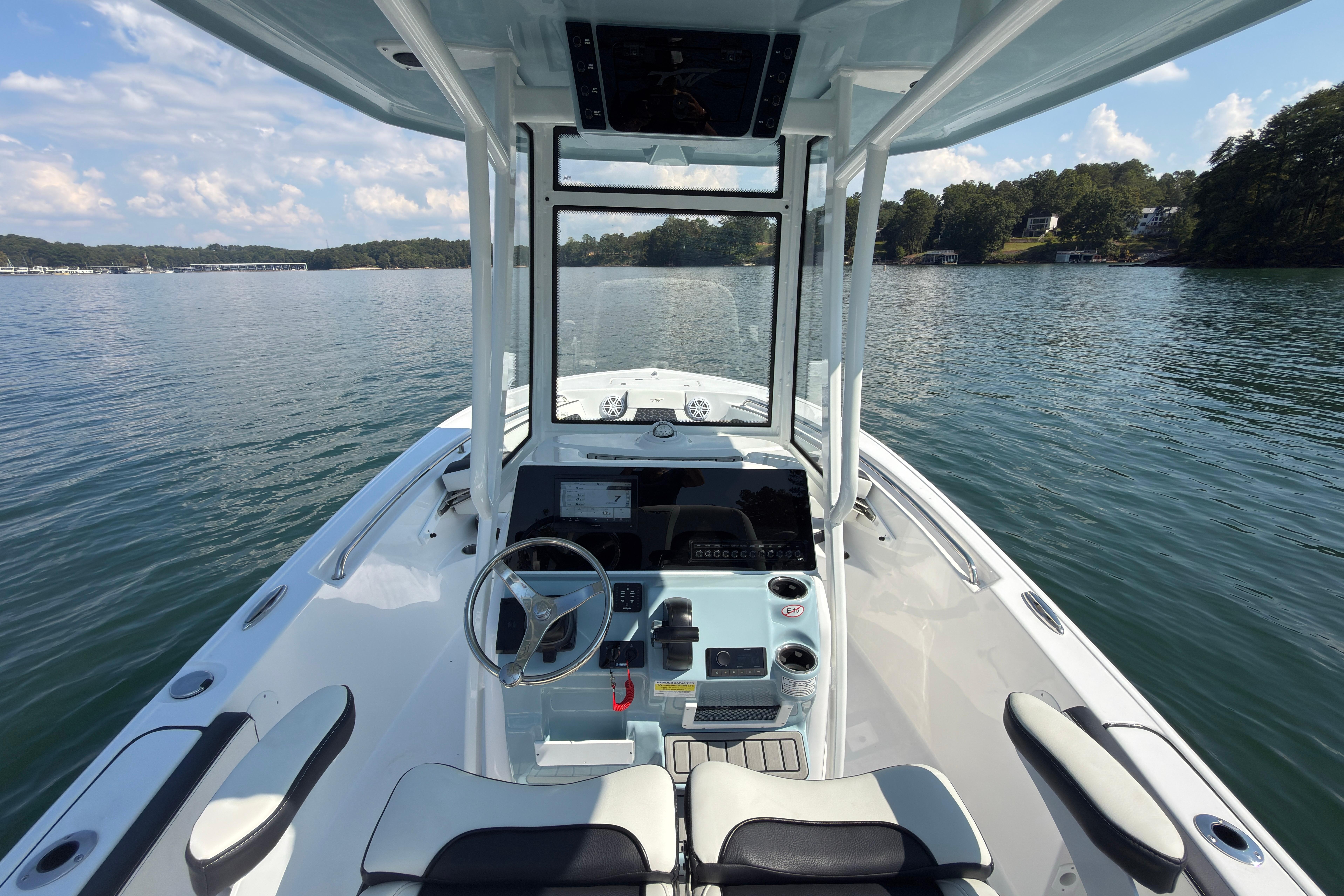2026 Tidewater 220 LXF boat interior with steering wheel, dashboard, and lake view.