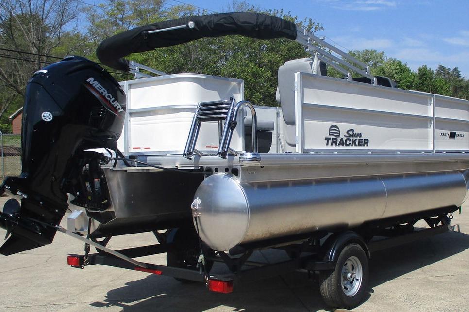 2026 Sun Tracker Party Barge 18 DLX pontoon boat on trailer, featuring Mercury outboard motor.