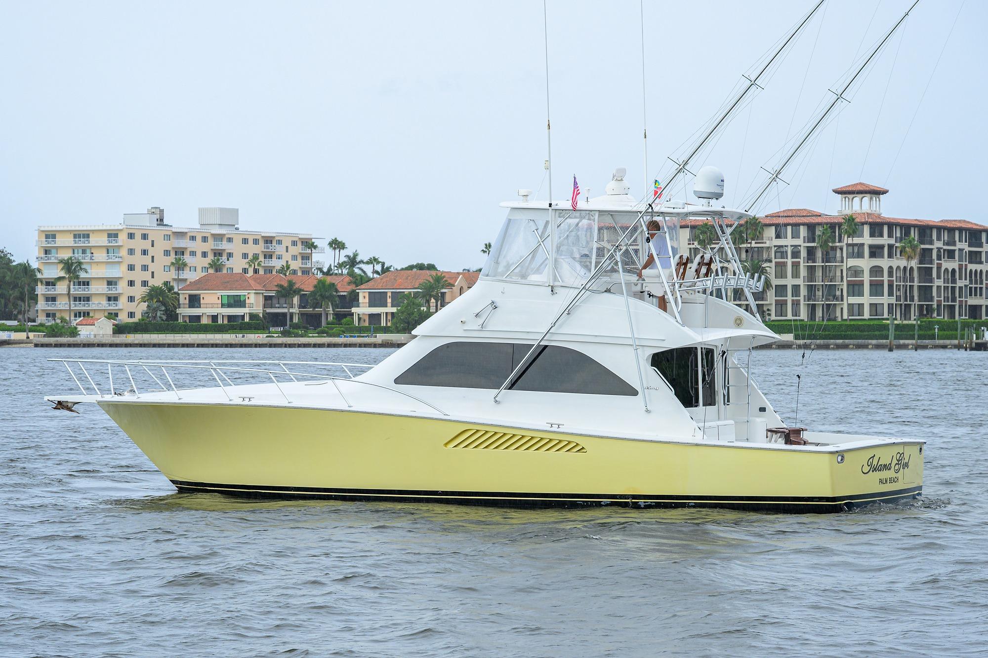 2004 Viking 48 Convertible yacht on water near luxury waterfront buildings.