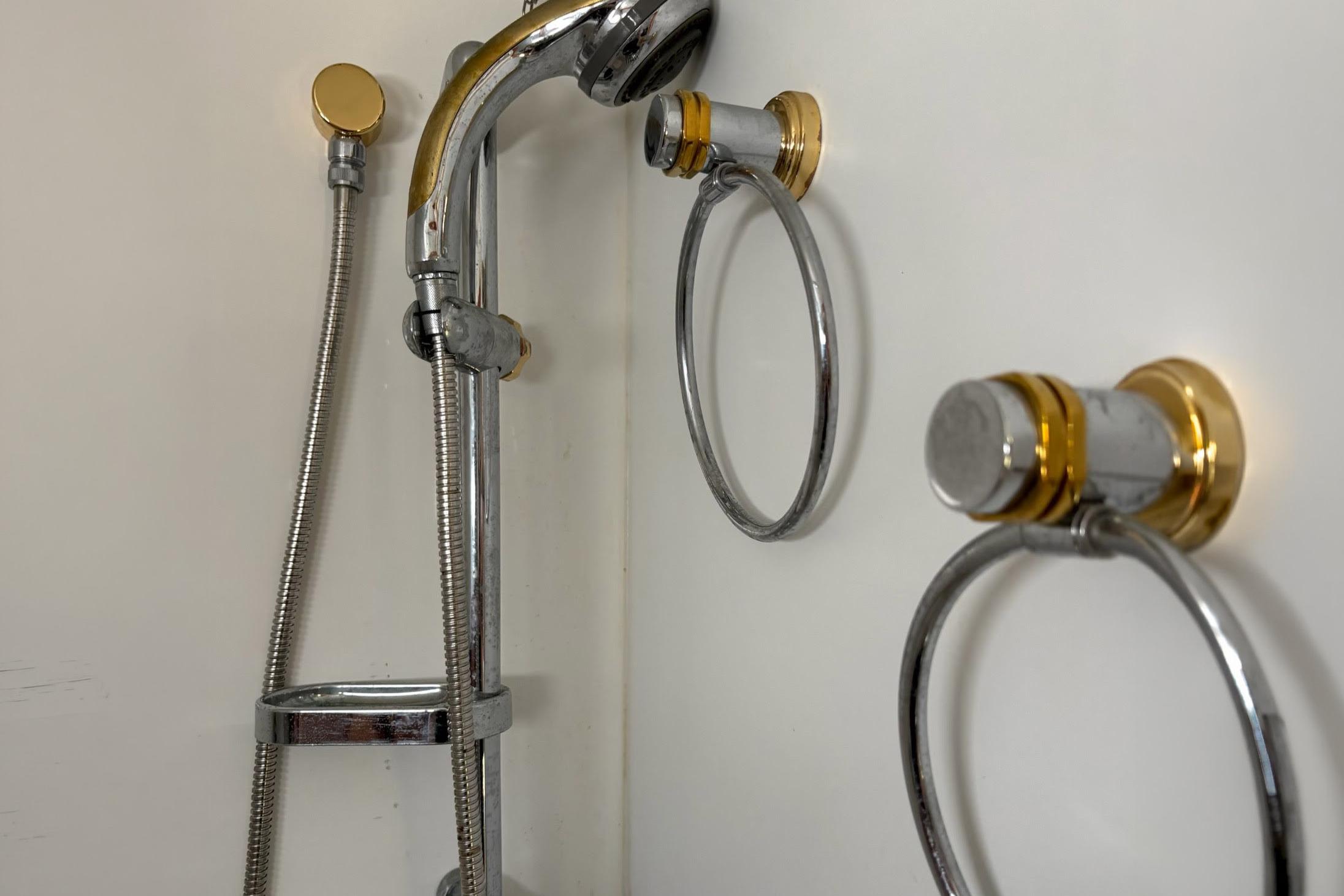 Shower fixtures with chrome and gold accents on a 2008 Stamas 370 Express boat.