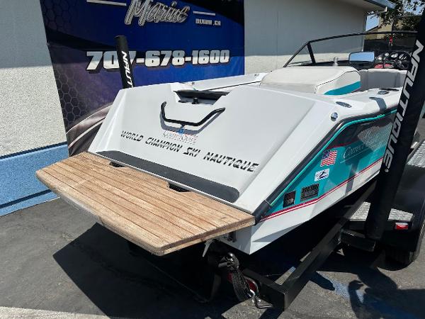 1992 Correct Craft Ski Nautique boat with wooden swim platform, displayed outdoors.