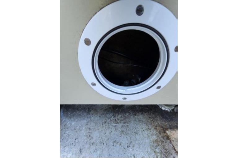 Circular porthole on 1985 Wasque Down East Cruiser, showcasing marine craftsmanship.