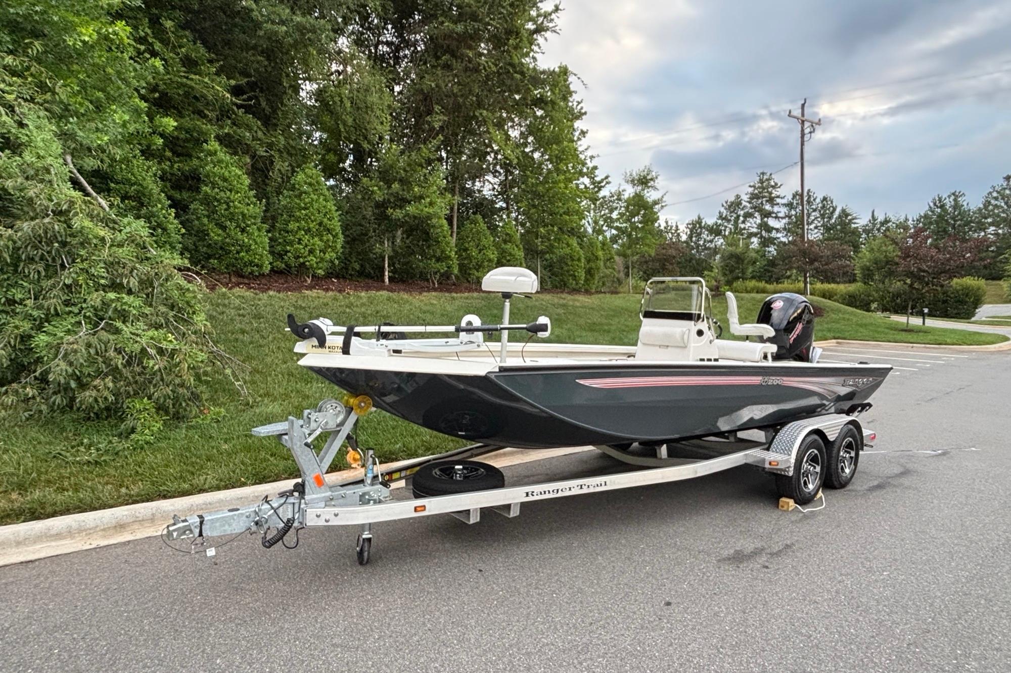 2024 Ranger RB200 boat on trailer, parked on roadside with lush greenery.