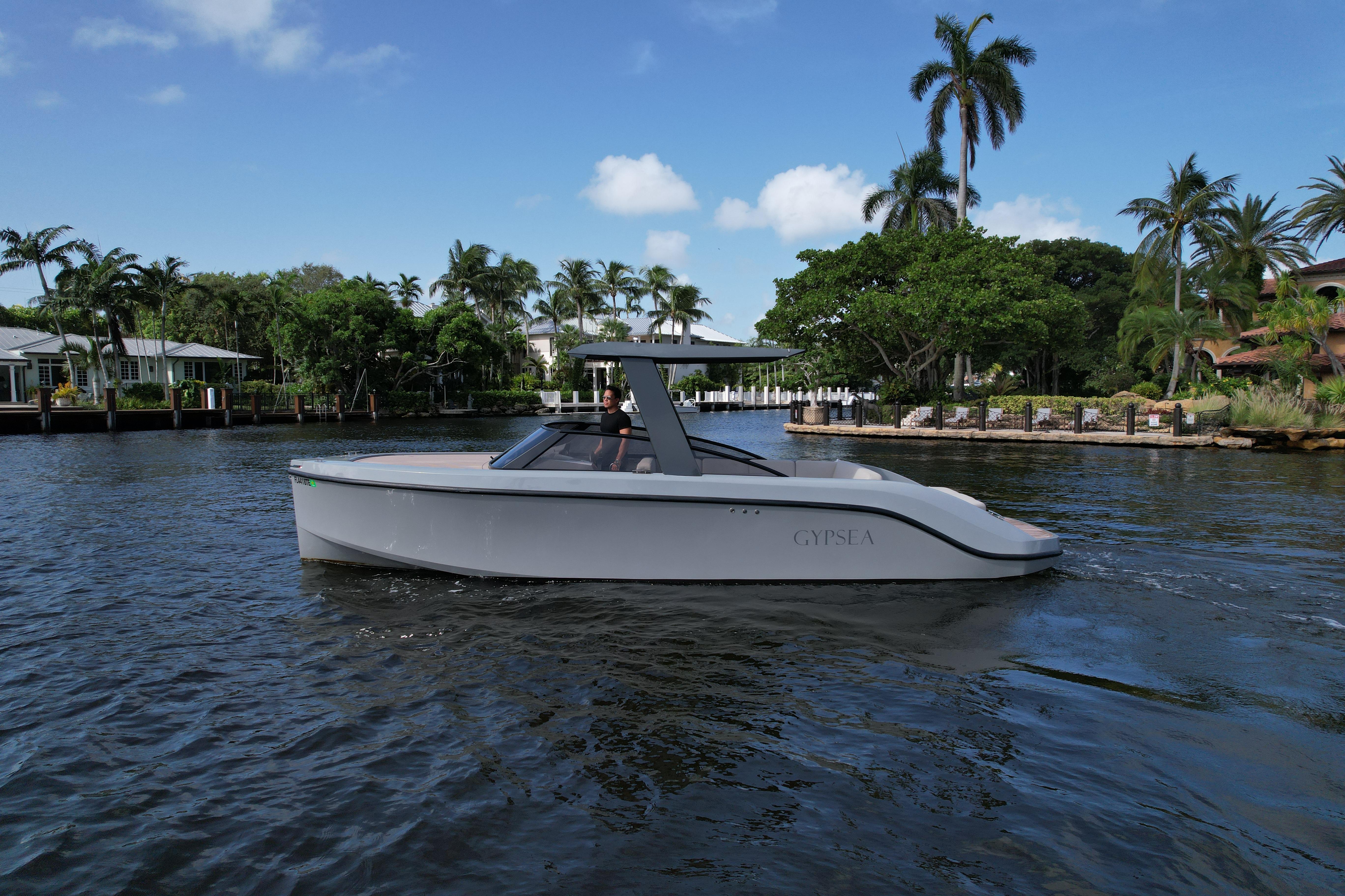 2021 Rand Leisure boat cruising on a tropical waterway with palm trees in the background.