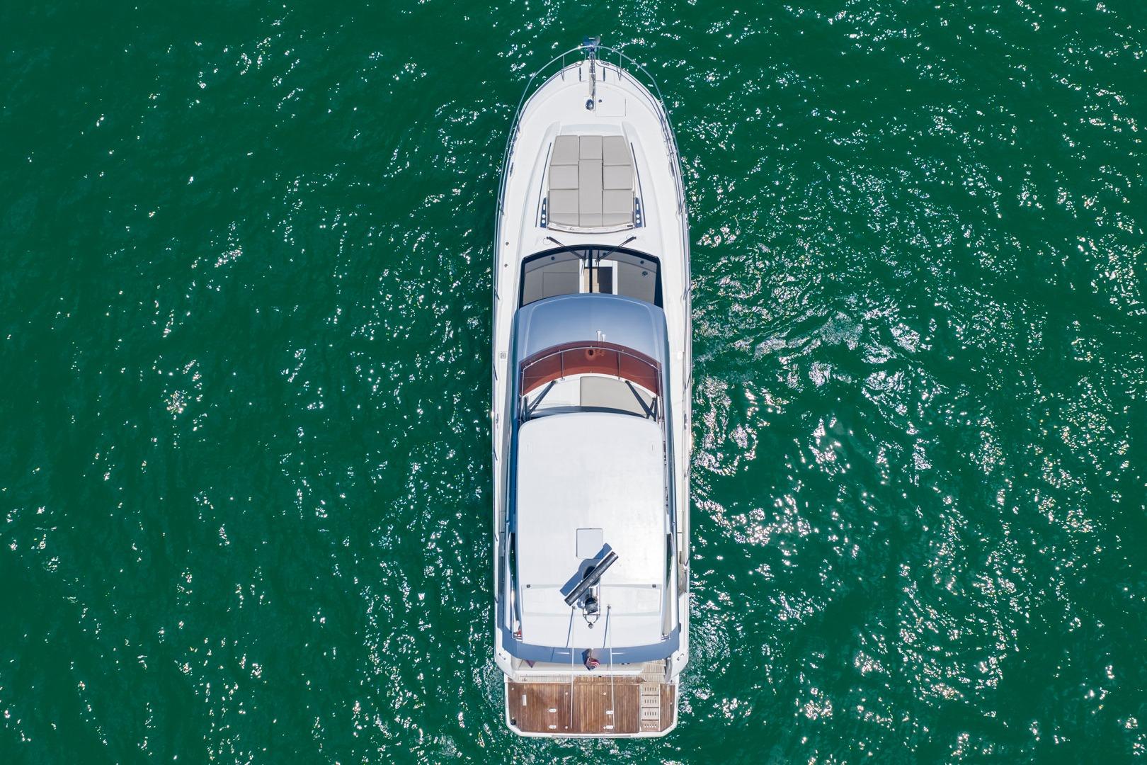 Aerial view of 2022 Prestige 520 yacht on vibrant green water.