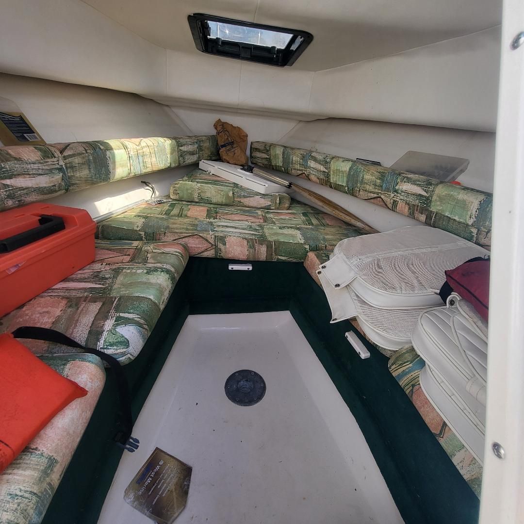 Interior of the 1998 Sport-Craft 211WAC with patterned cushions and storage space.