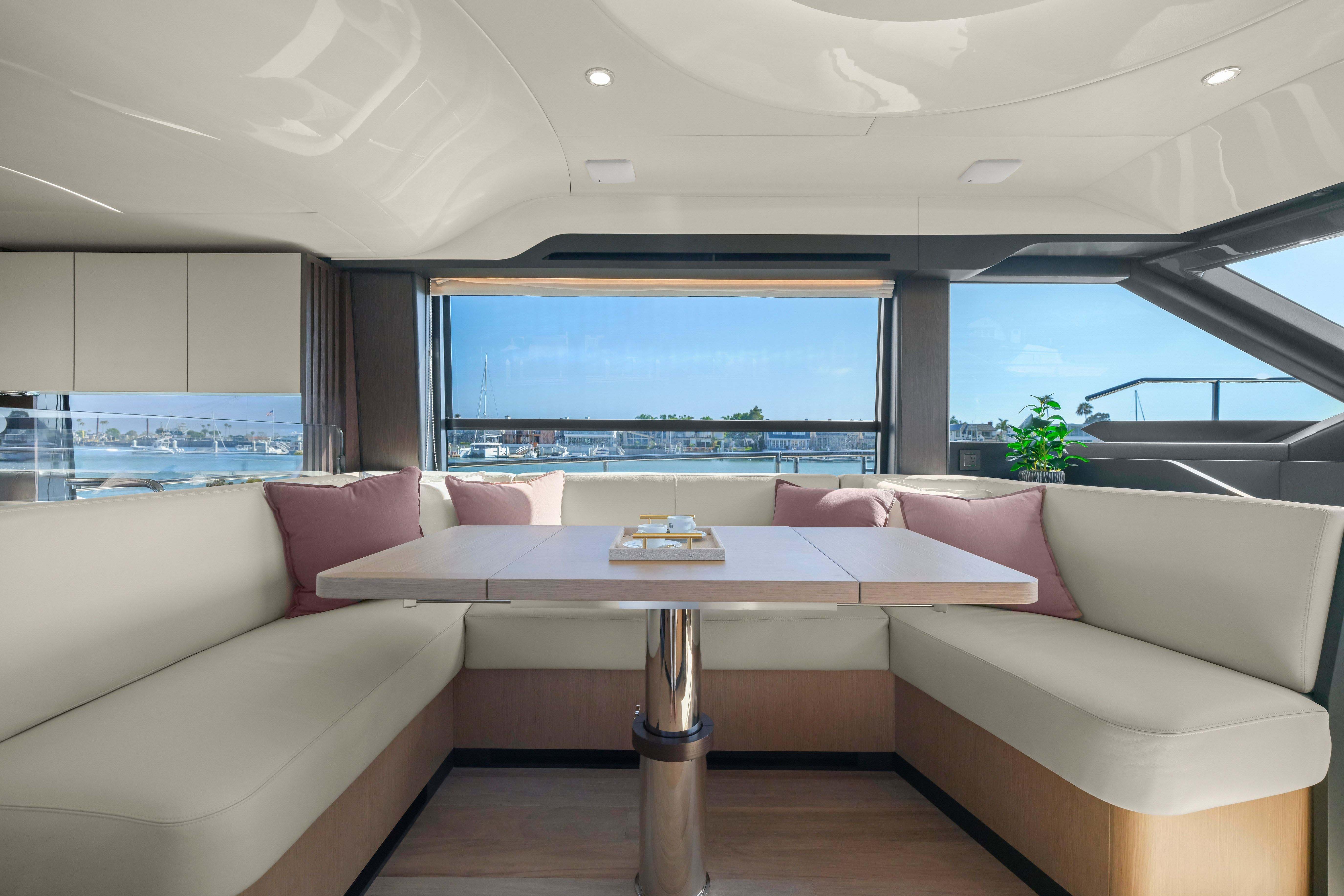 Luxurious interior of 2026 Absolute 52 Fly yacht with elegant seating and scenic window view.