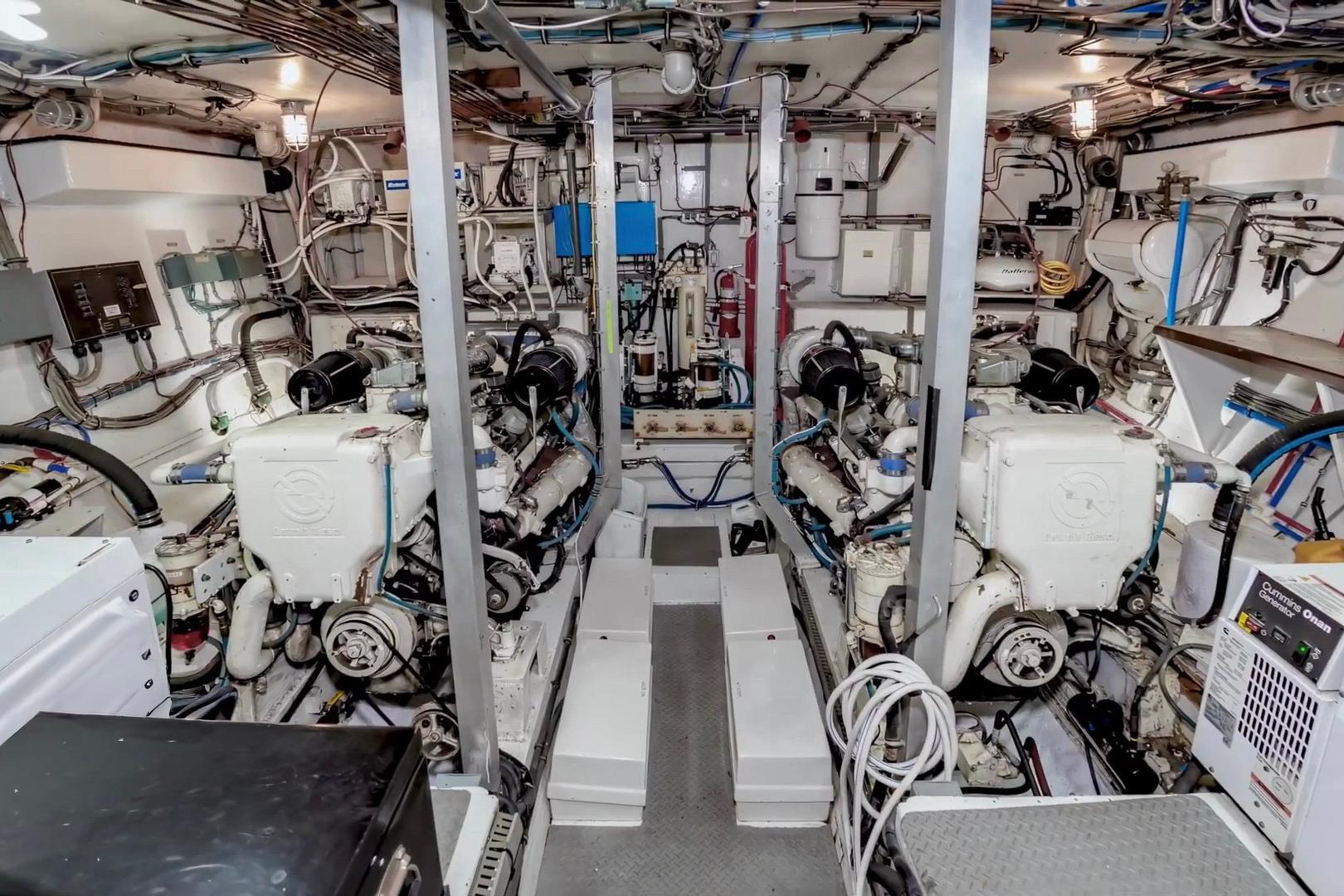 Engine room of a 1980 Hatteras 70 Motor Yacht, showcasing dual engines and complex wiring.