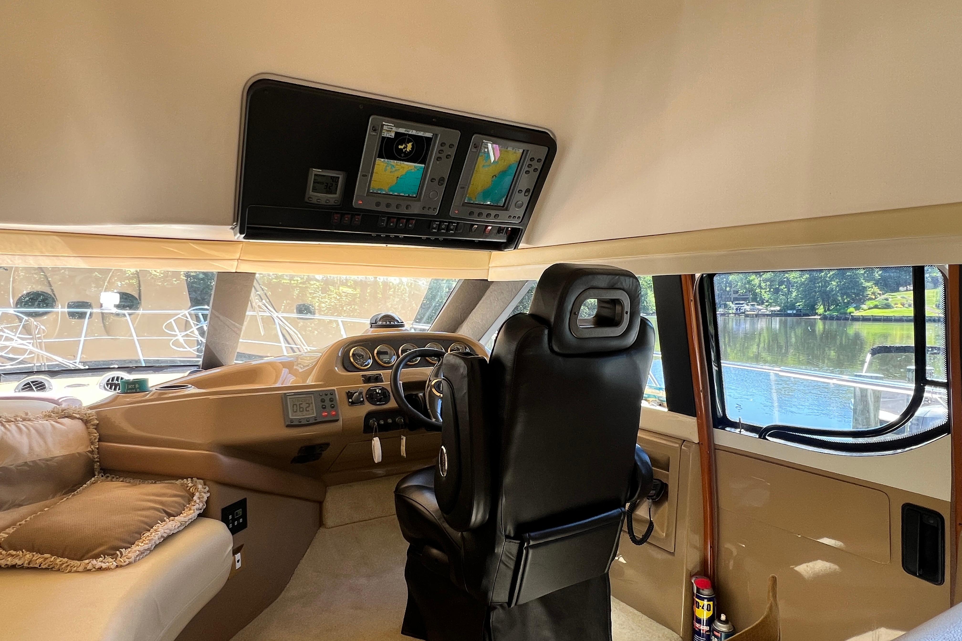 Interior of 2003 Carver 450 Voyager Pilothouse with navigation screens and captain's chair.