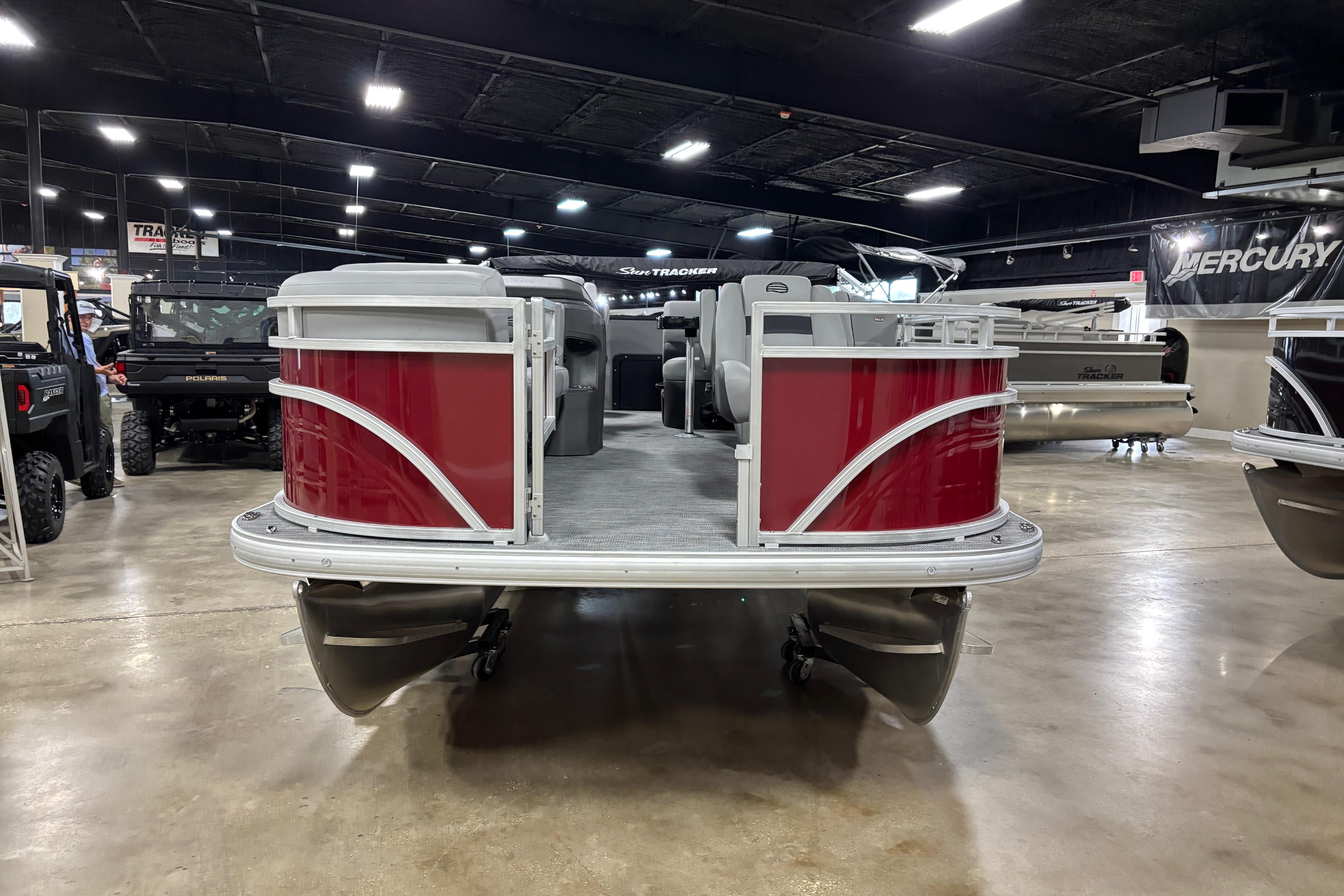 2026 Sun Tracker SportFish 20 DLX pontoon boat displayed indoors, featuring red exterior.