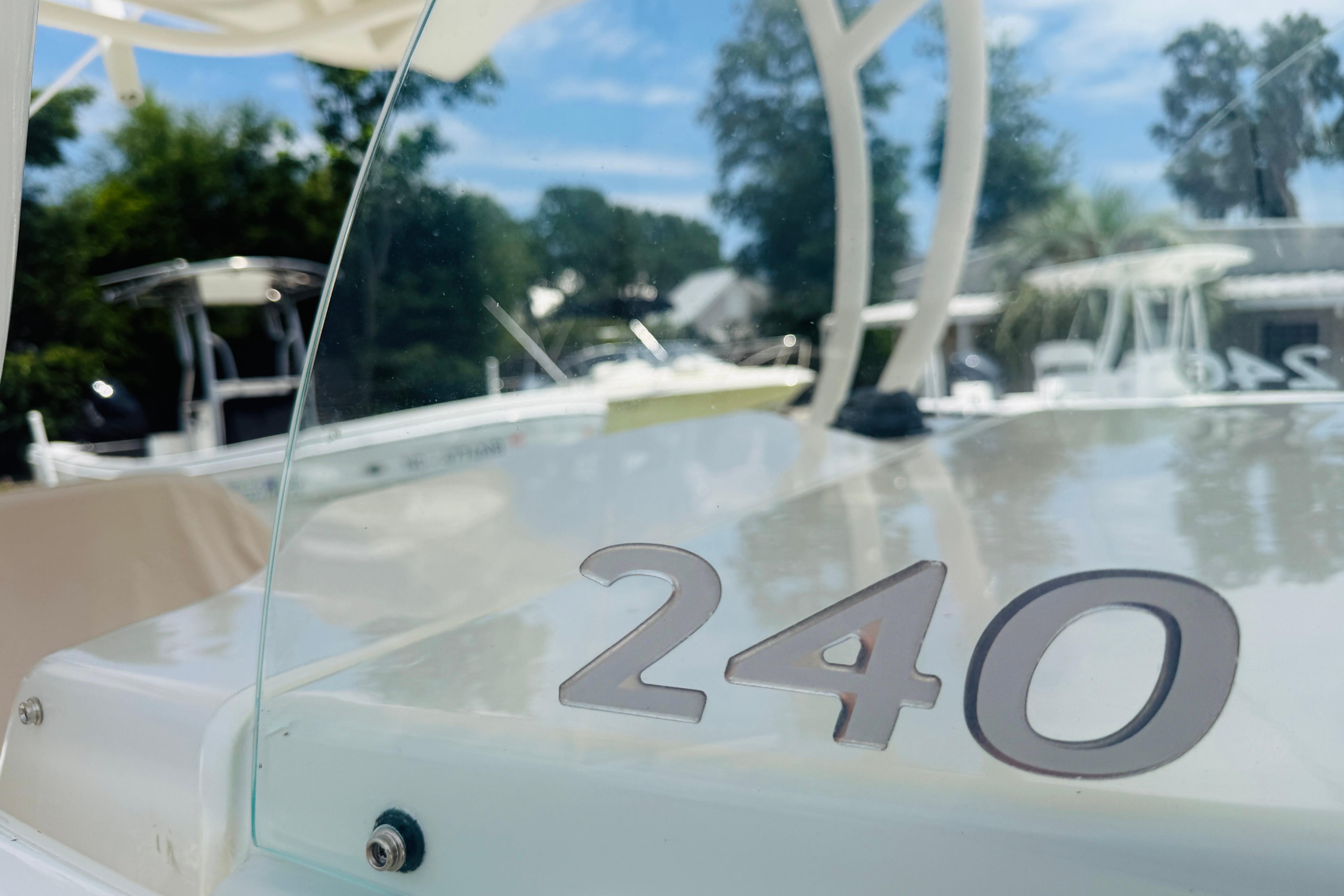 2015 Sailfish 240 CC boat with clear windshield, outdoors in a marina setting.