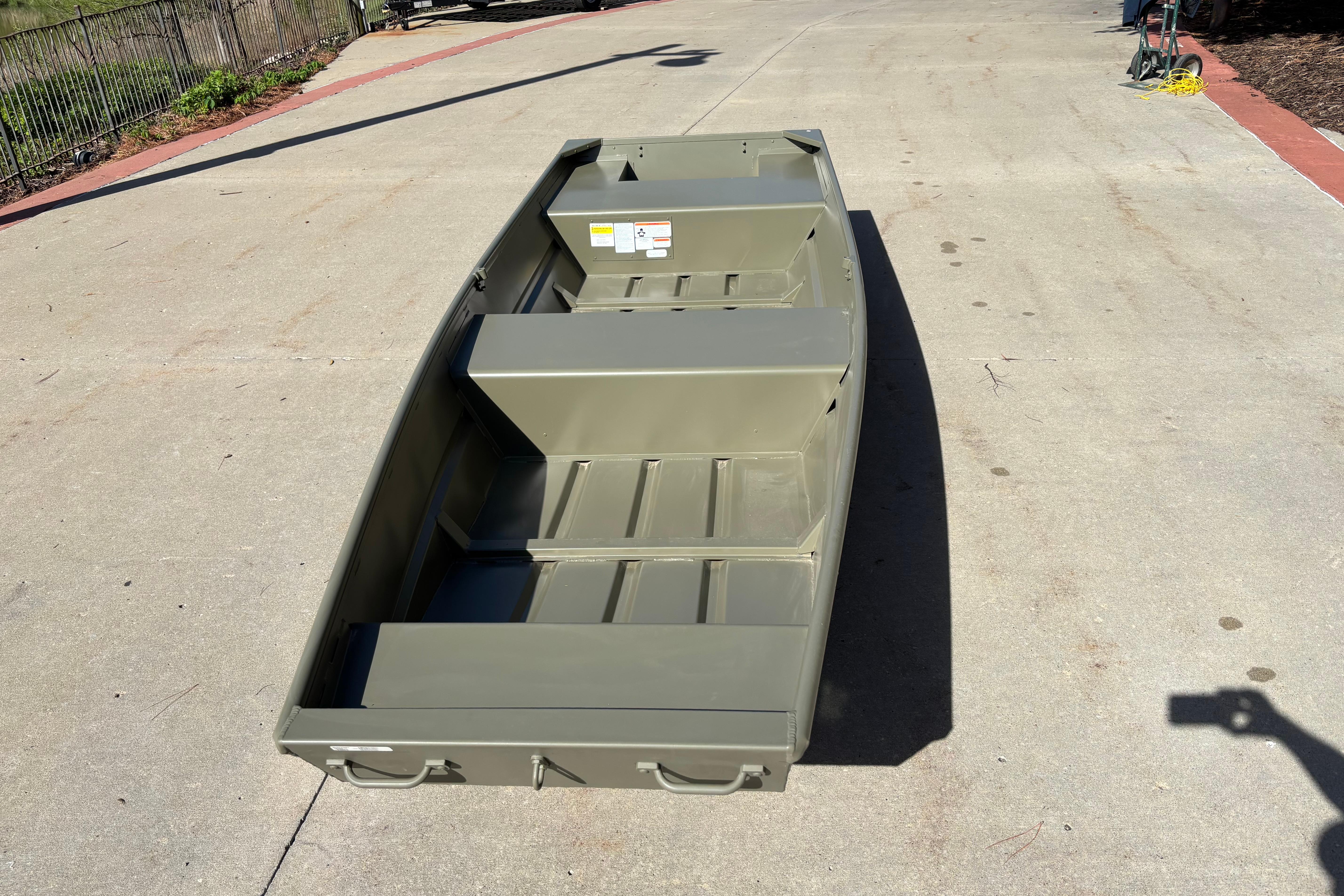2026 Tracker Grizzly 14 Jon boat on concrete surface, showcasing its sturdy design.