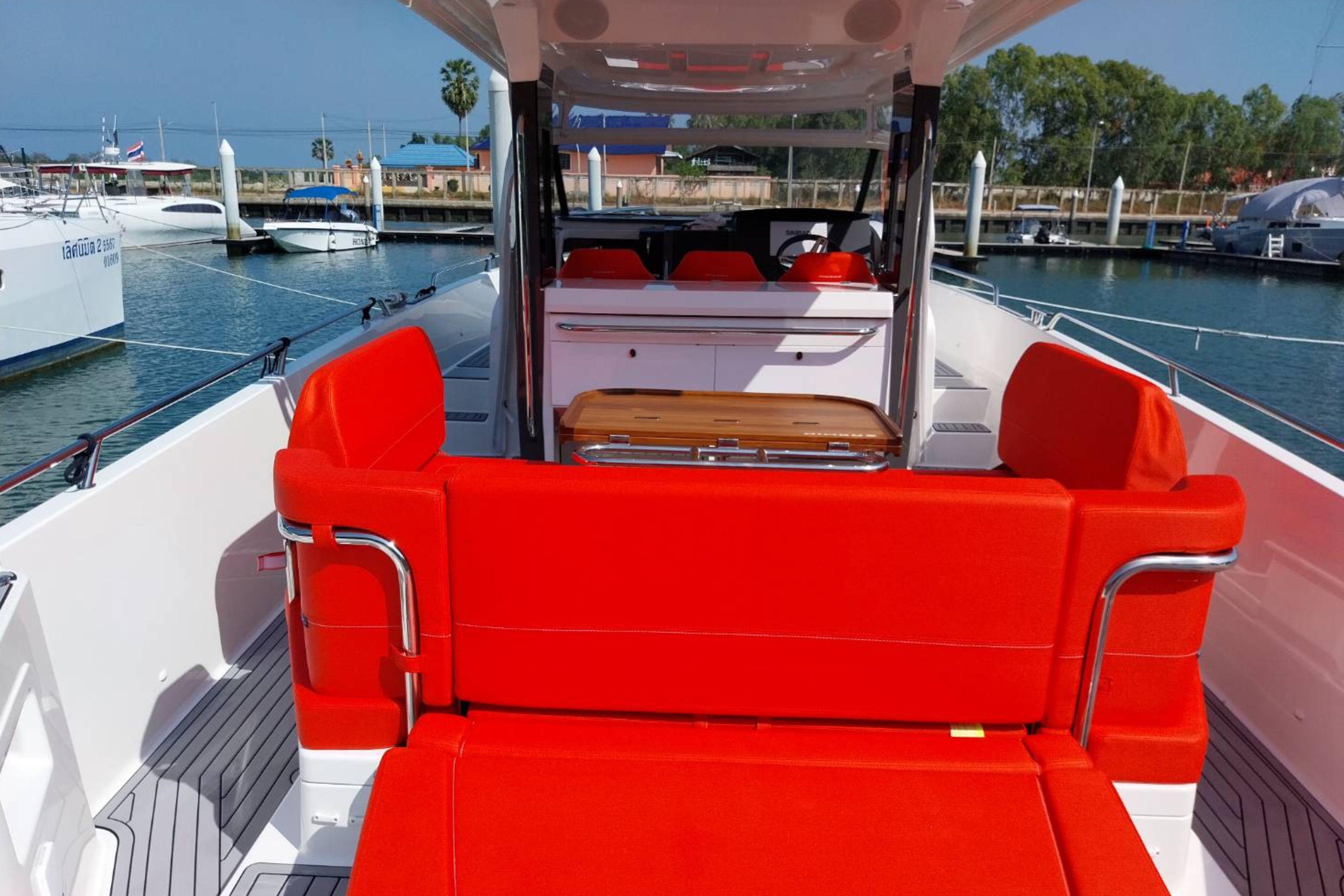 2023 Nimbus T11 boat with vibrant red seating and sleek design in a marina setting.