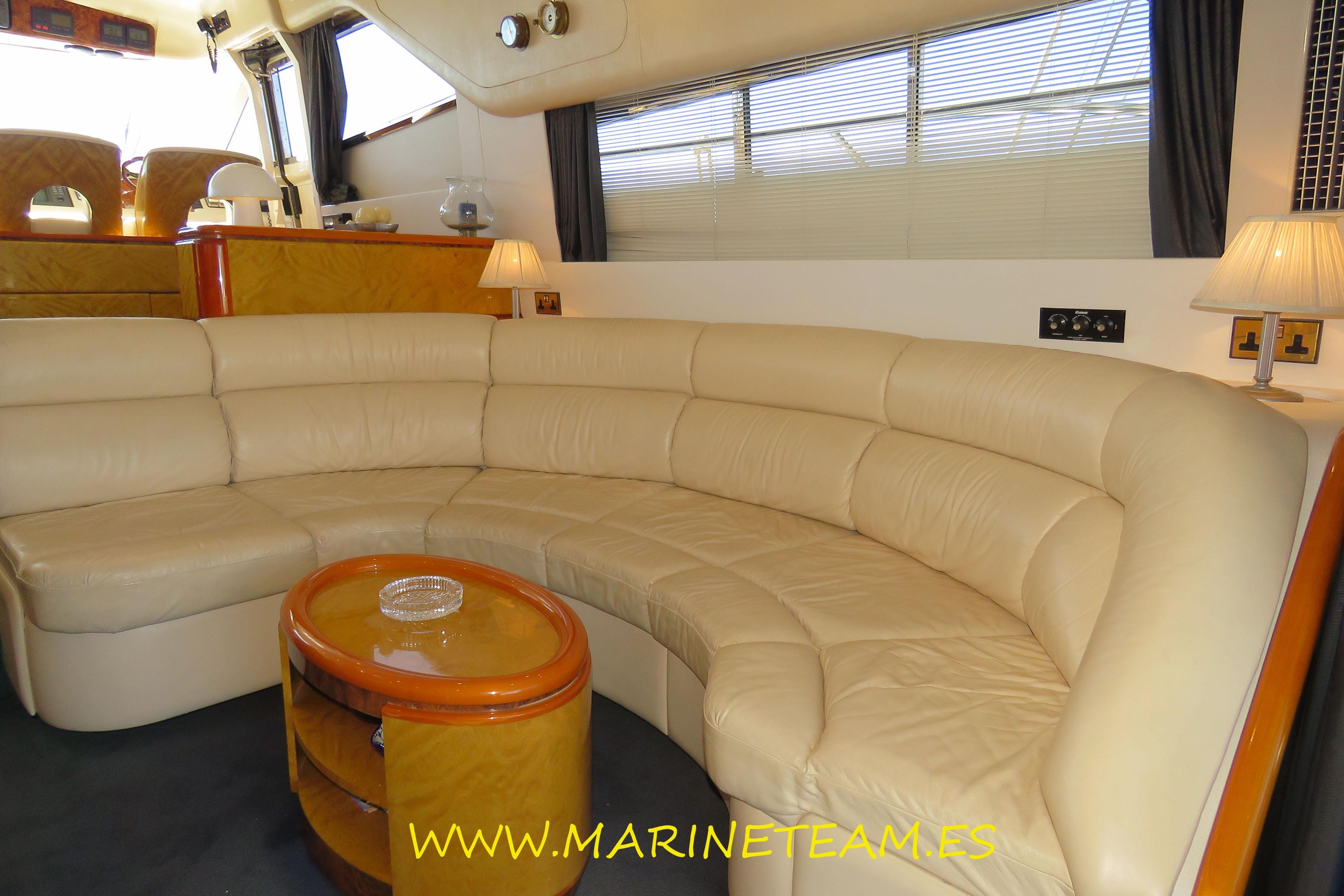 Luxurious interior of a 1995 Princess 60 yacht with cream leather seating and elegant decor.
