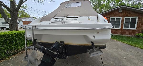 1999 Sea Ray 280 SS boat parked in driveway, rear view with cover.