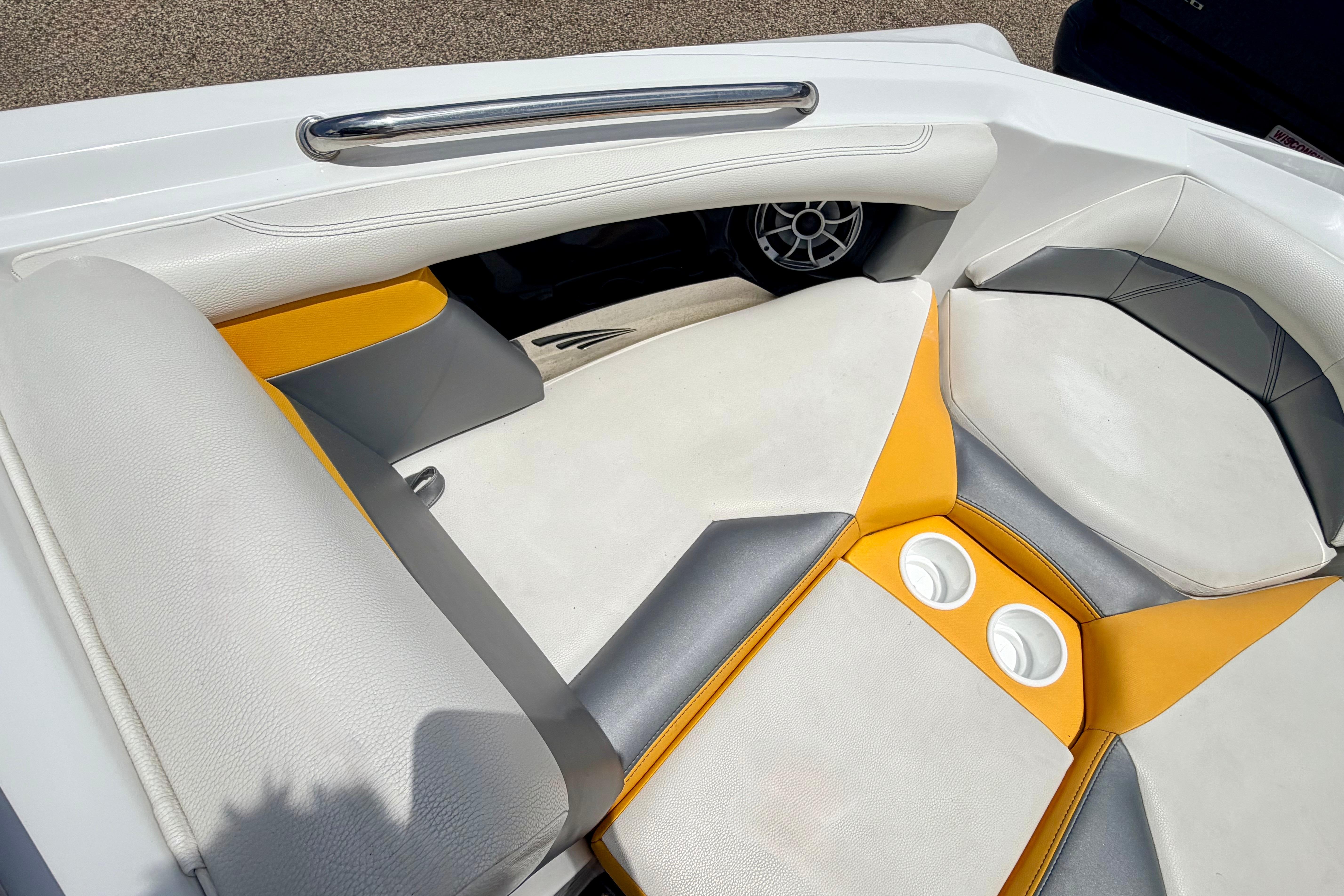Interior of 2014 Tigé R20 boat with white and yellow seating, featuring cup holders.