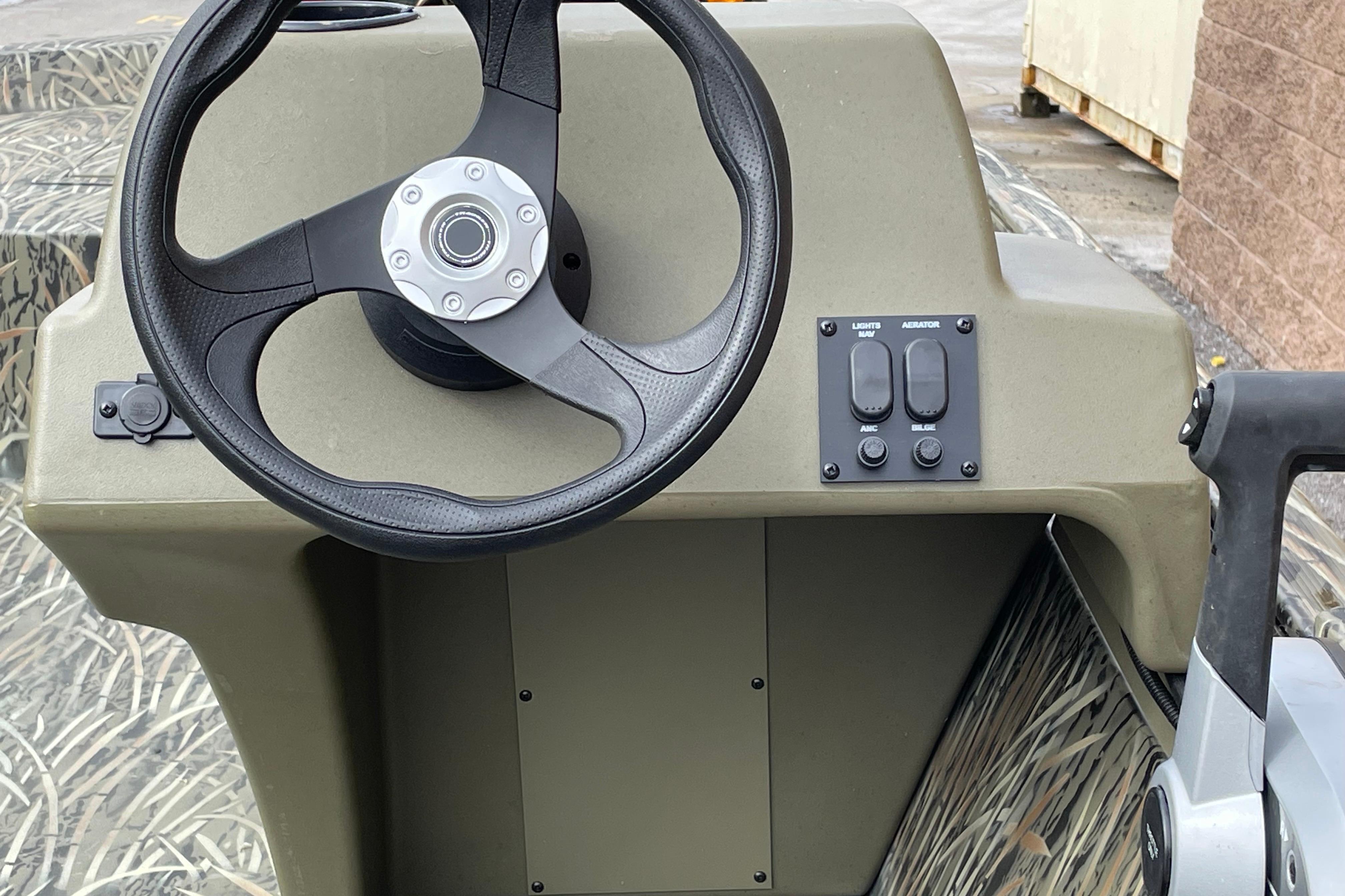 2026 Tracker Grizzly 1648 SC boat console with steering wheel and control panel.
