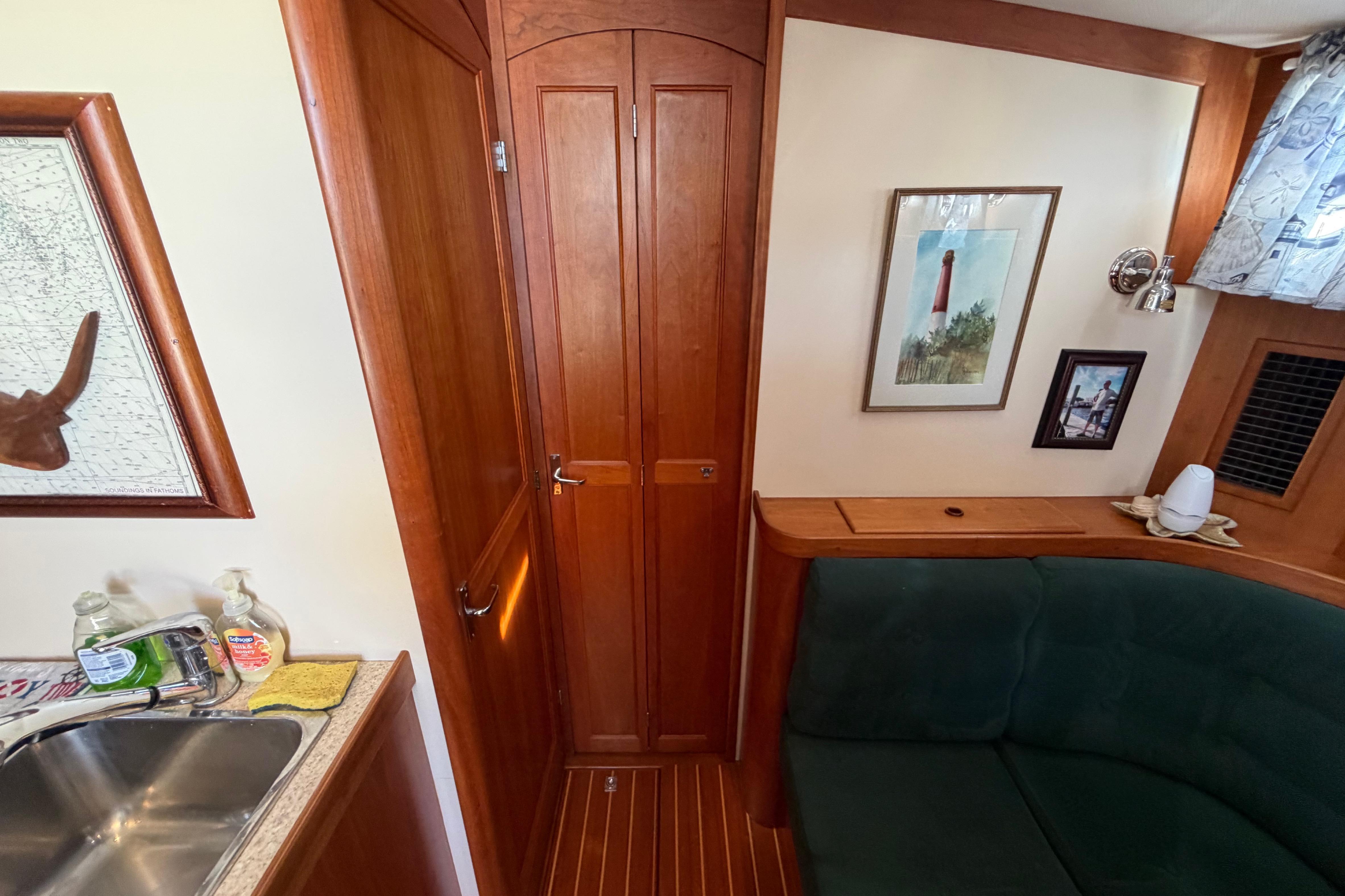 Interior of 2000 Sabreline 36 Express yacht with wood paneling and cozy seating area.