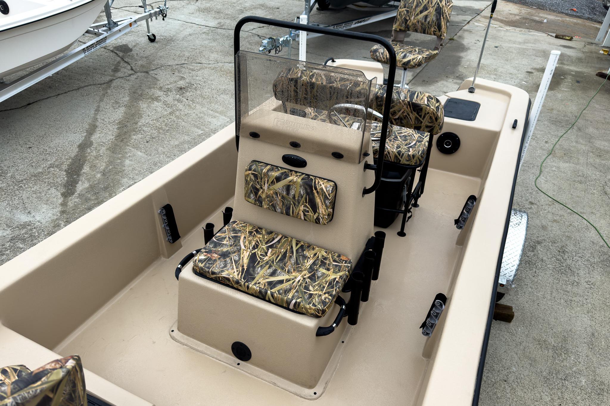 2026 Carolina Skiff E18 JVX CC Sportsman boat with camo seats, parked on a trailer.