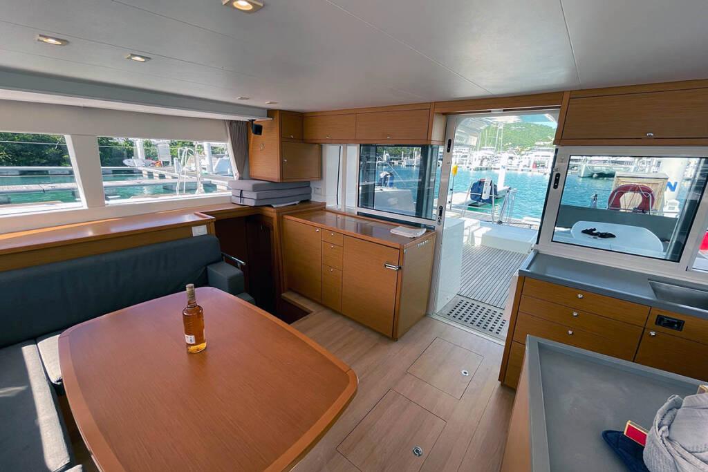 Interior of 2018 Lagoon 450 F catamaran with dining area and outdoor view.