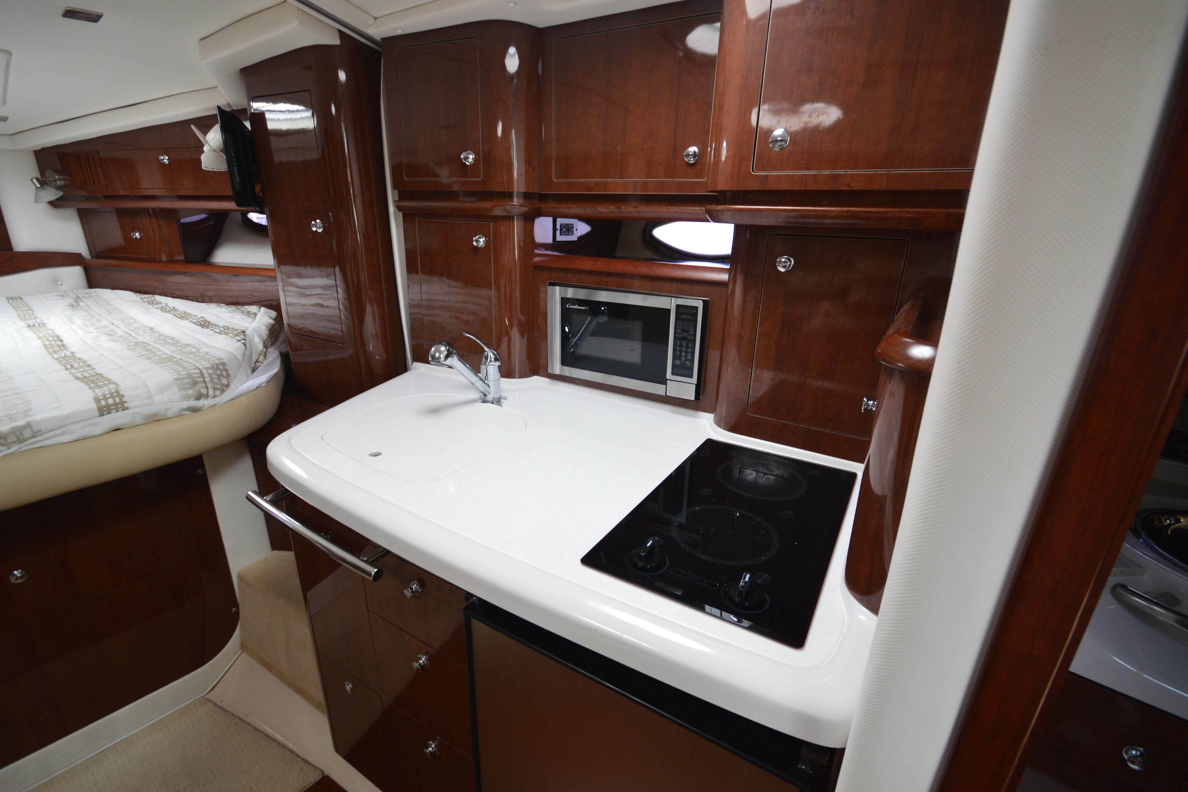 Luxurious 2013 Four Winns V375 yacht interior with kitchenette and bed.