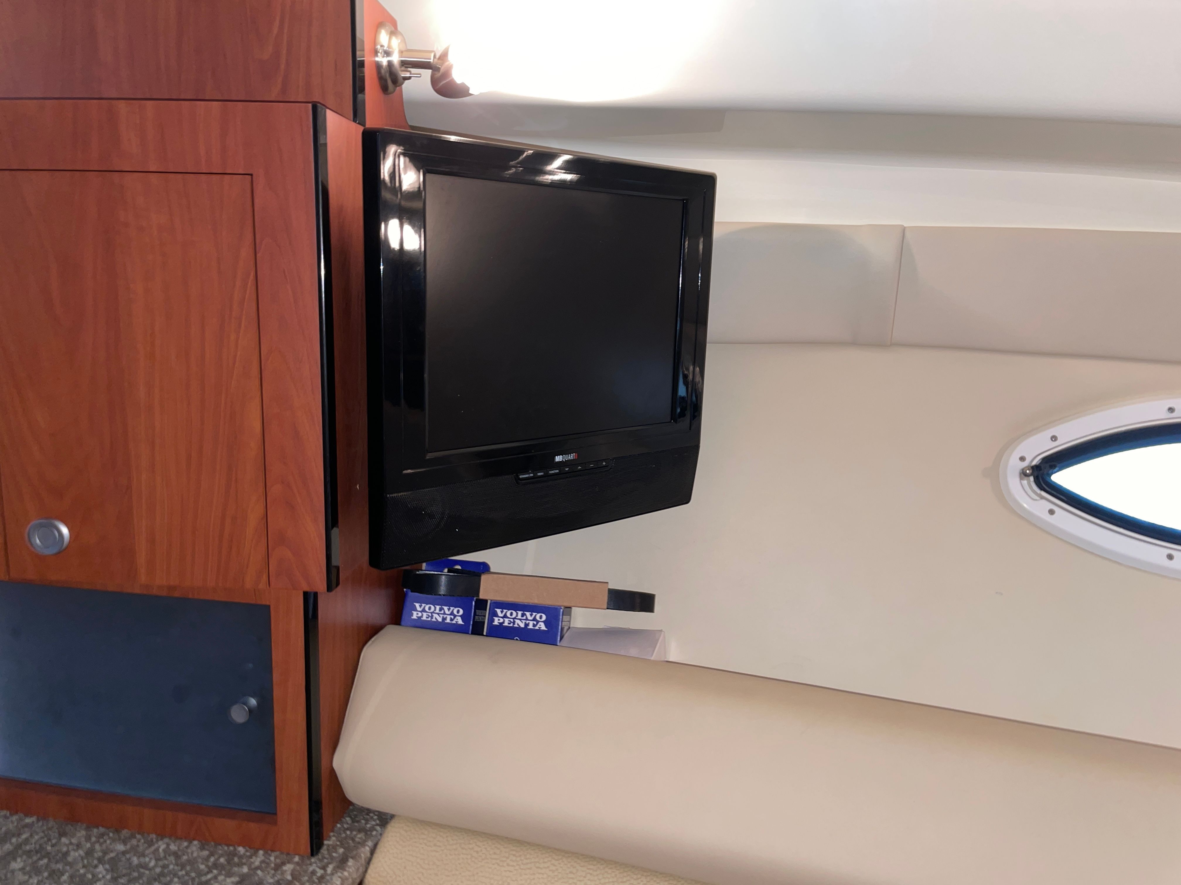 Interior of a Monterey 280 Sport Cruiser with TV and wooden cabinet.
