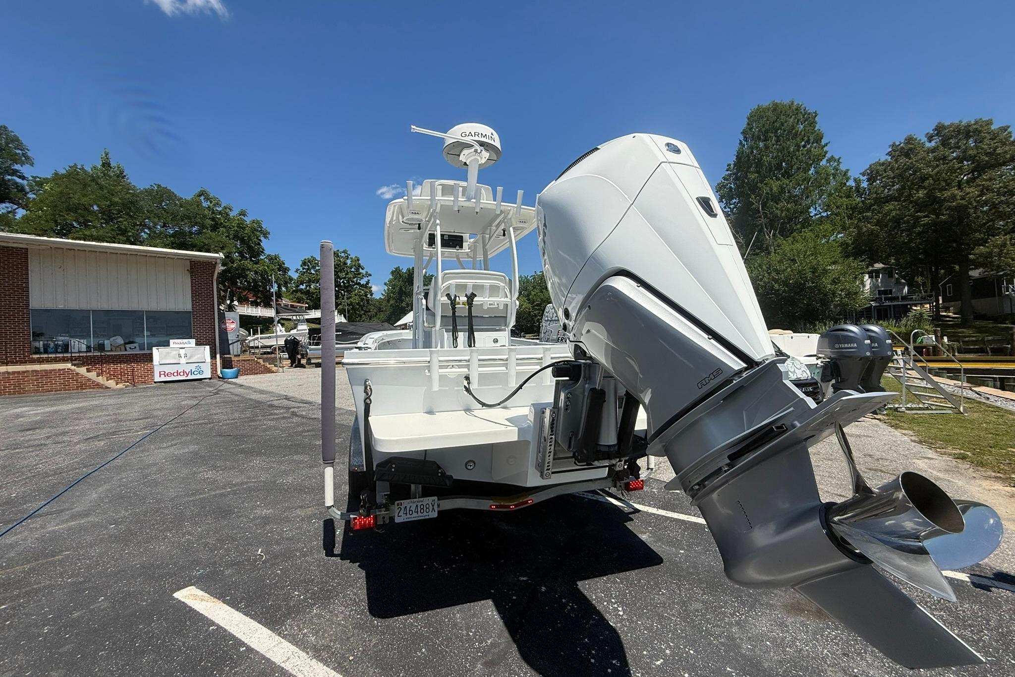 2024 Pair Customs 24 Center Console MV boat with powerful outboard motor in a parking lot.