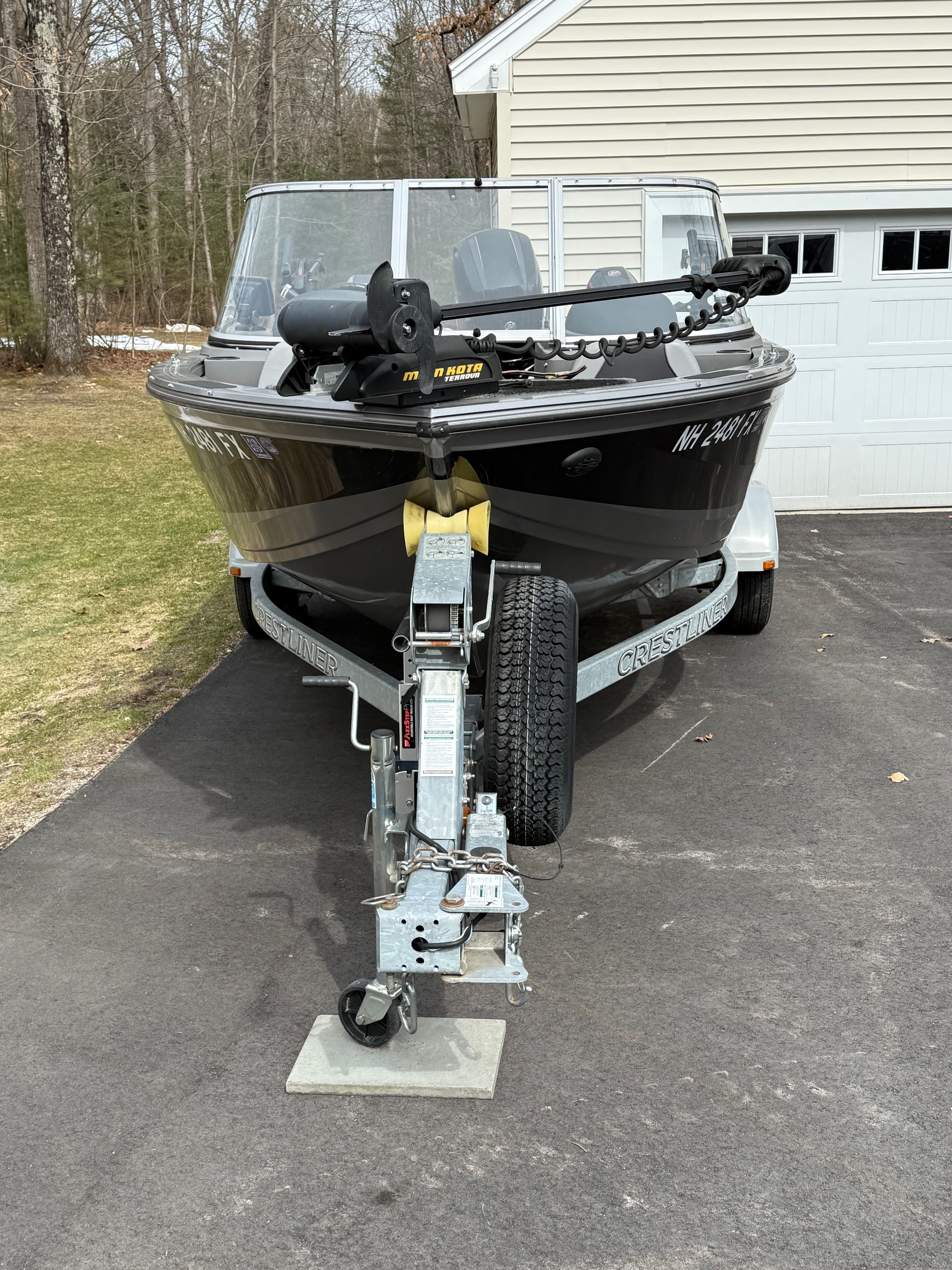 2015 Crestliner 1850 boat on trailer in front of garage.