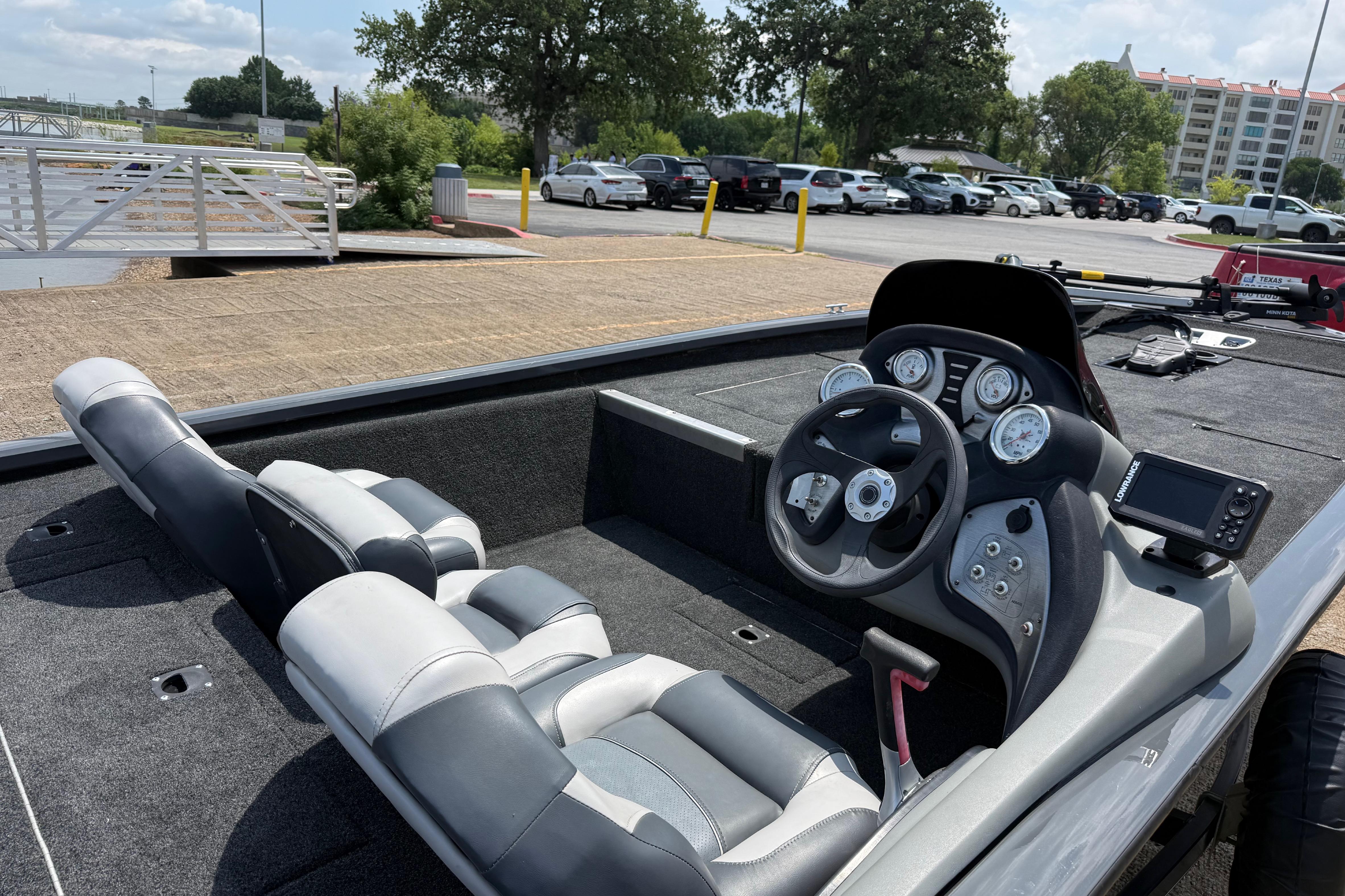2015 Tracker Pro Team 190 TX boat interior with steering wheel and seating, parked near a marina.