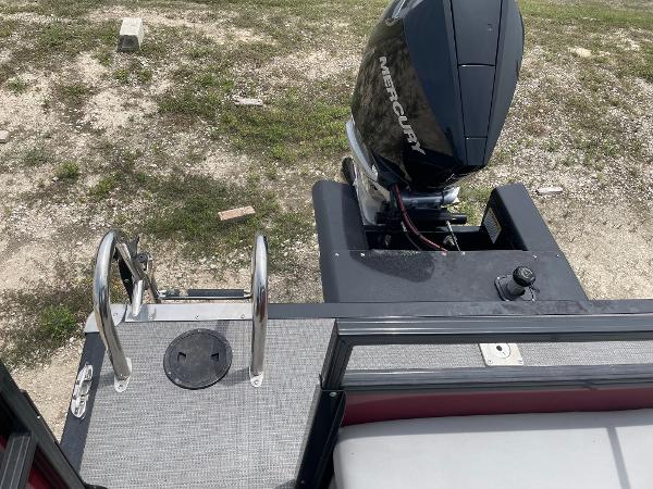 2023 Regency 250DL3 boat with Mercury engine, rear view showing ladder and deck.
