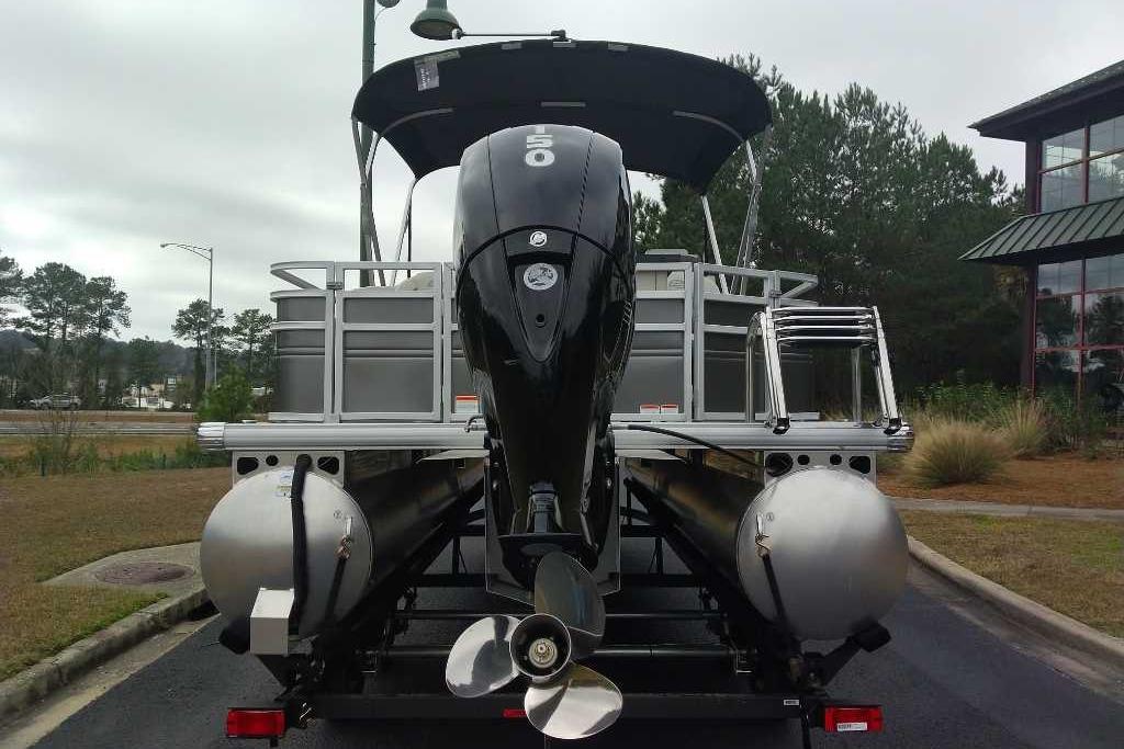 2026 Sun Tracker Fishin' Barge 22 DLX pontoon boat with powerful outboard motor.