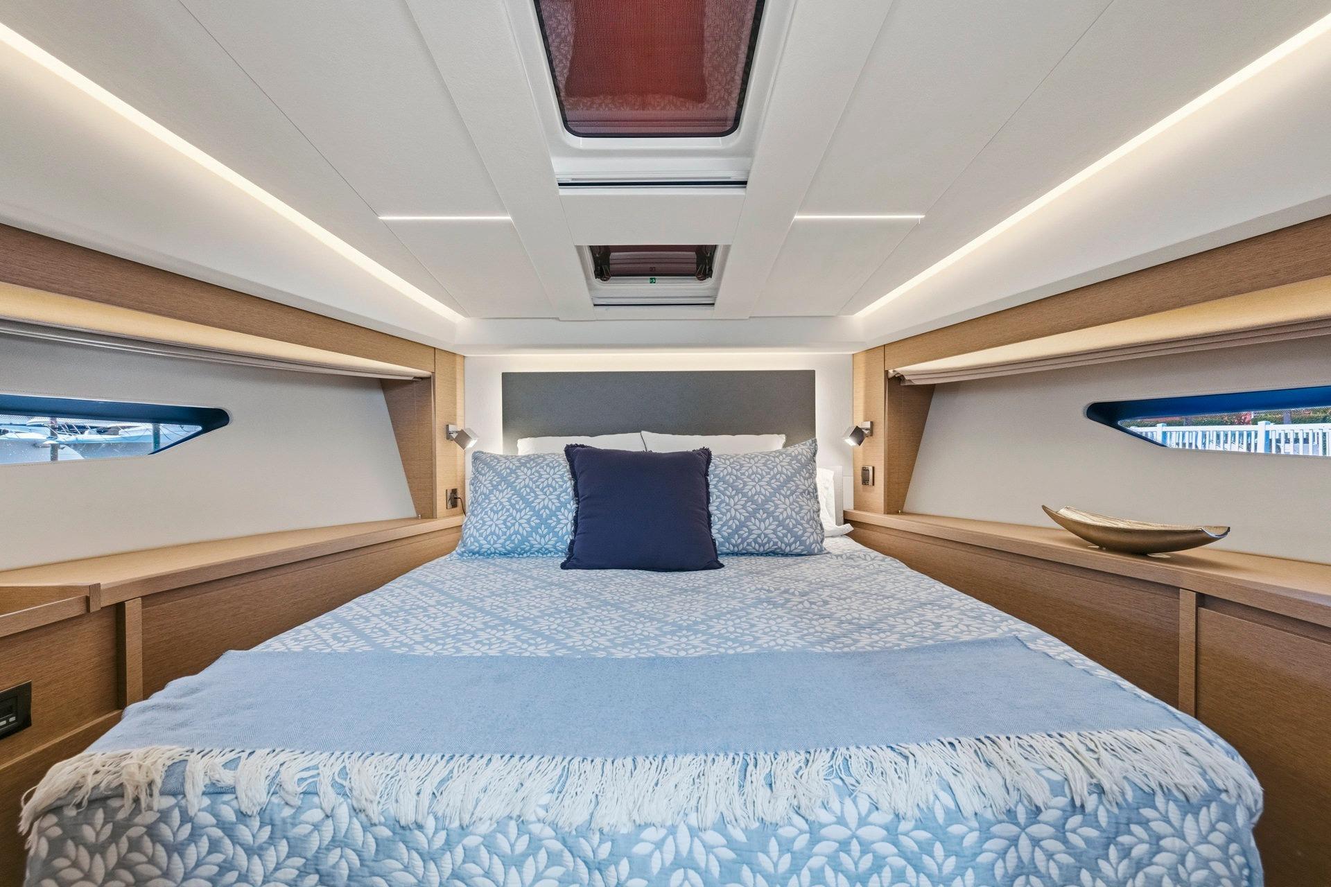 Luxurious cabin interior of 2022 Prestige 520 yacht with elegant bedding and modern design.