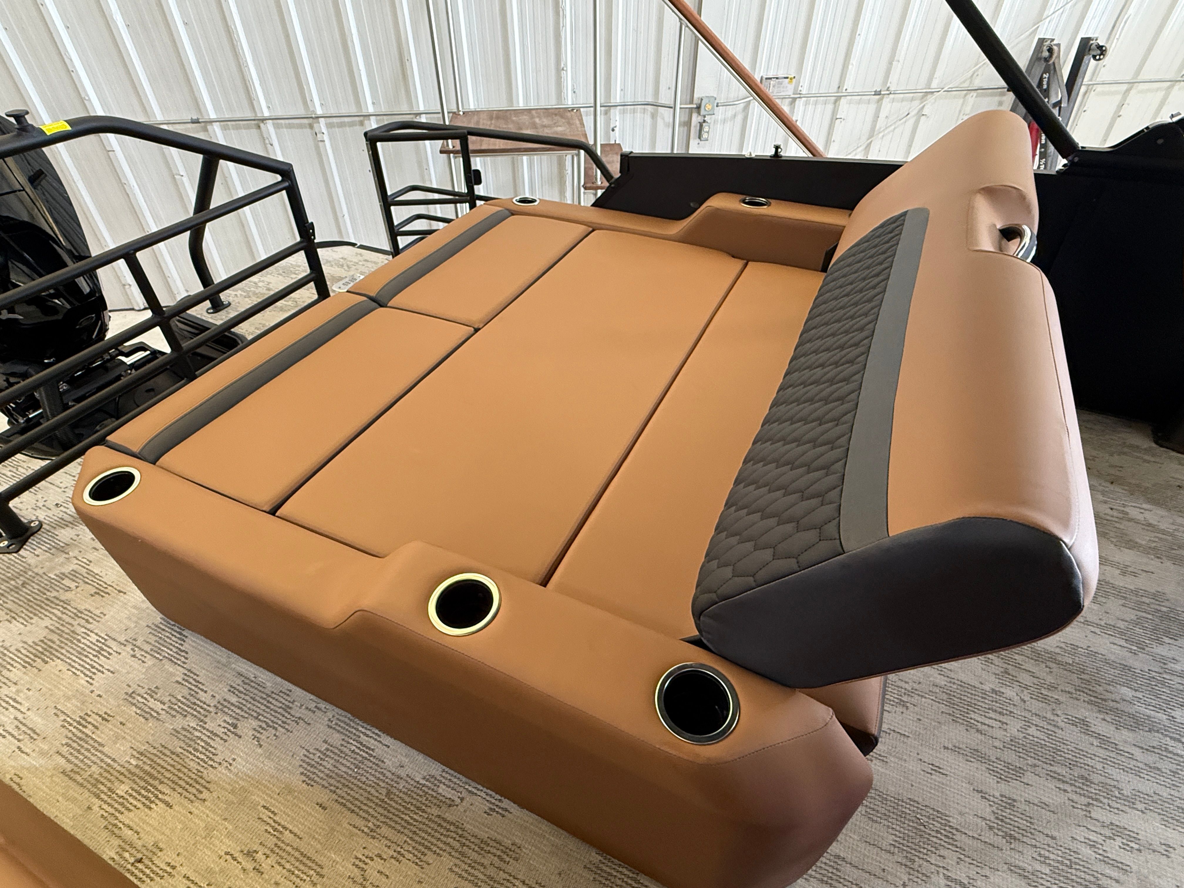 The image shows a luxurious brown boat seat with cup holders in a warehouse.