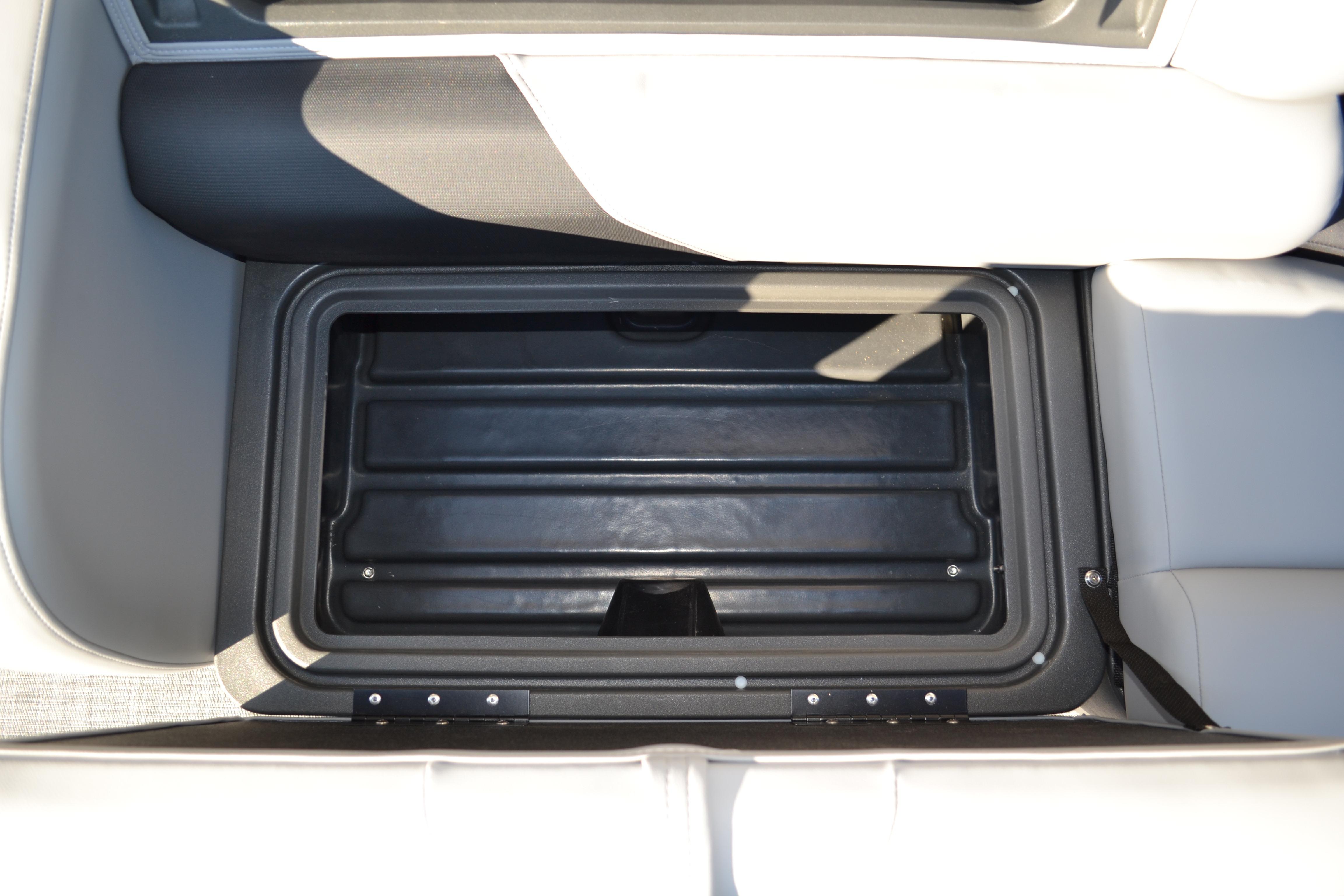 2026 Sun Tracker SportFish 22 XP3 storage compartment with open lid, showcasing interior space.