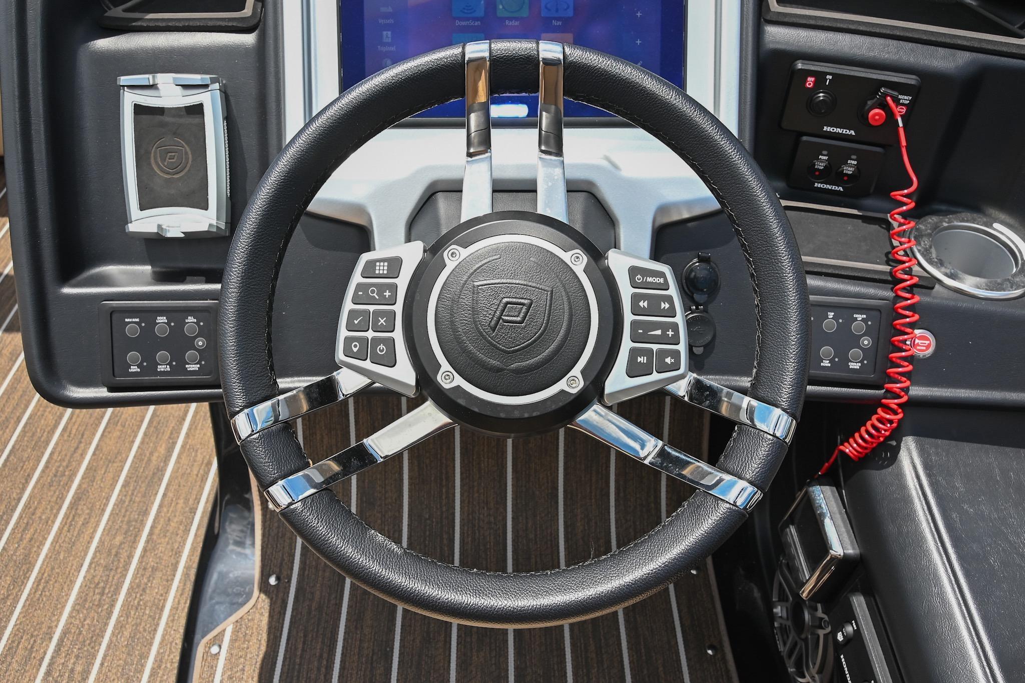 Steering wheel of 2023 Premier 270 Intrigue RF boat with control buttons and dashboard.