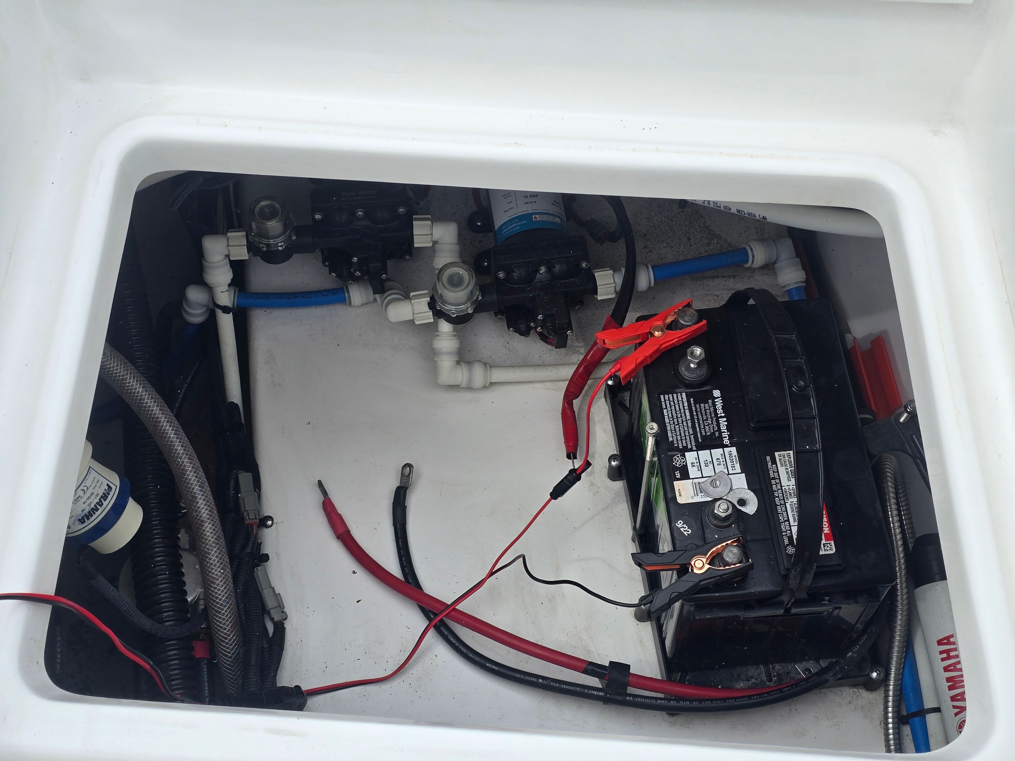 View of a boat engine compartment with battery and wiring.