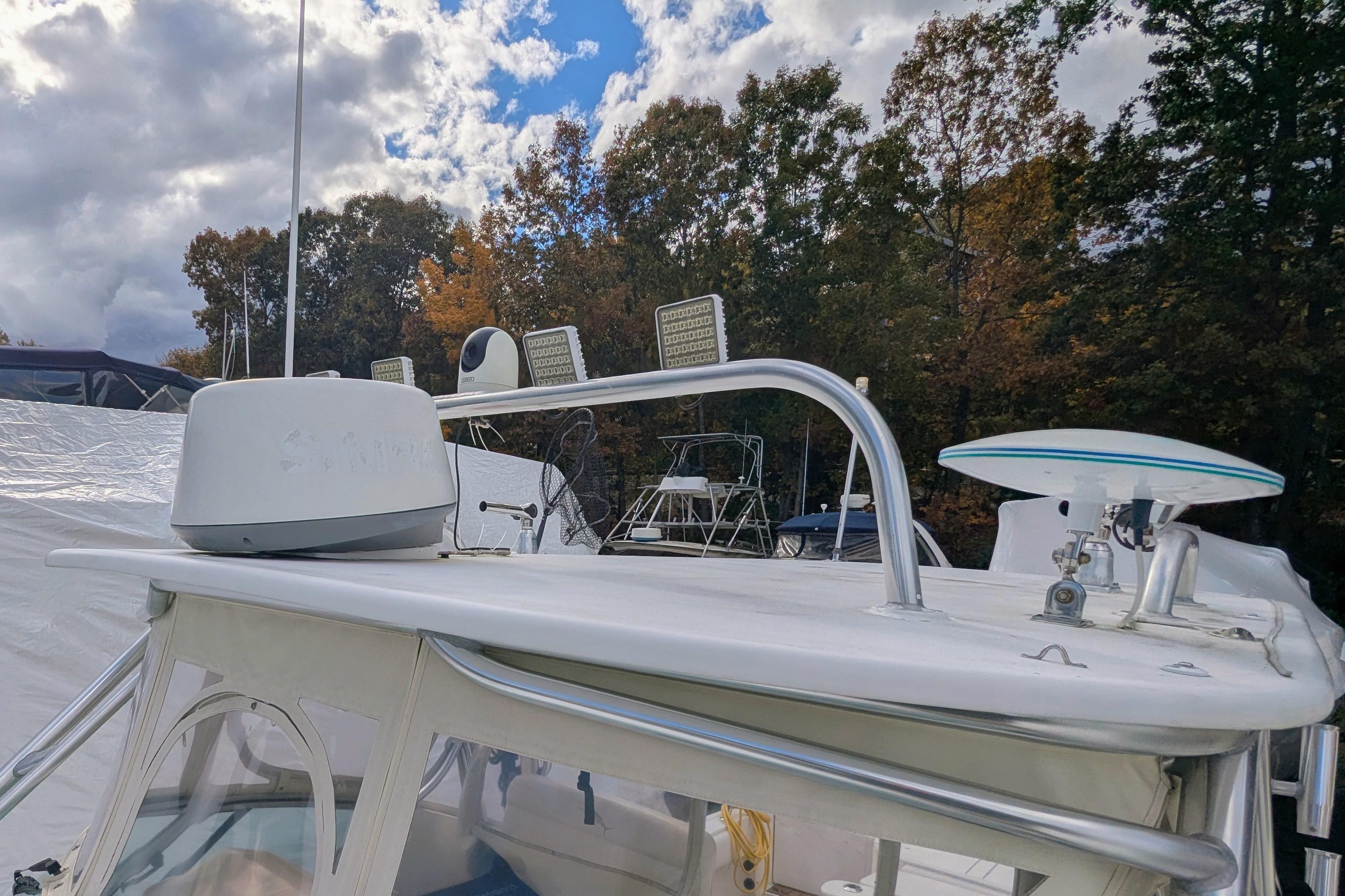 2002 Stamas 340 Express boat with radar and antenna, docked under cloudy sky.