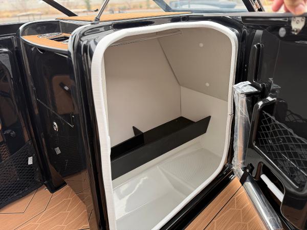 2025 Yamaha Boats 255XD storage compartment with sleek black and white interior design.