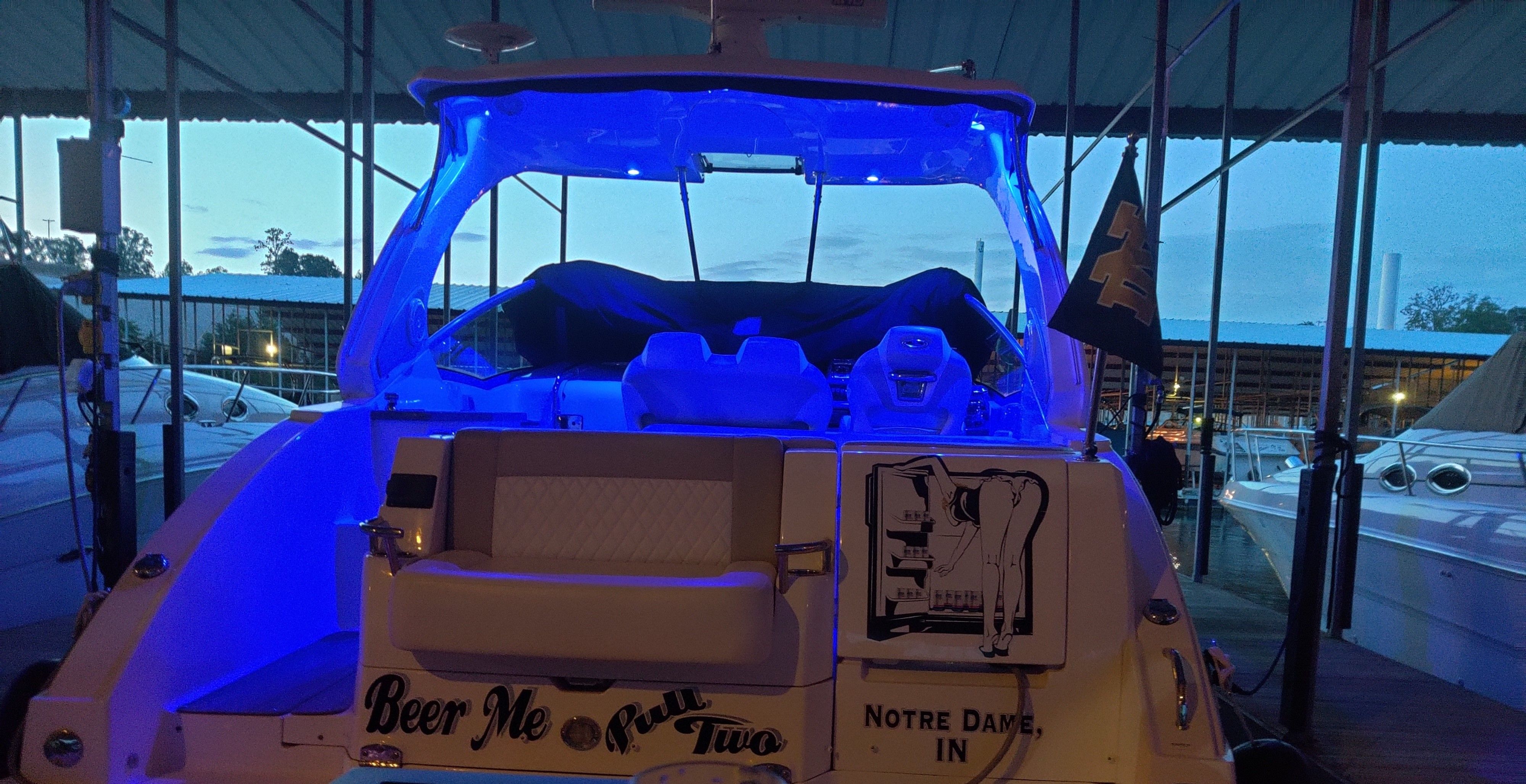 2014 Chaparral 330 Signature boat with blue lighting in marina.